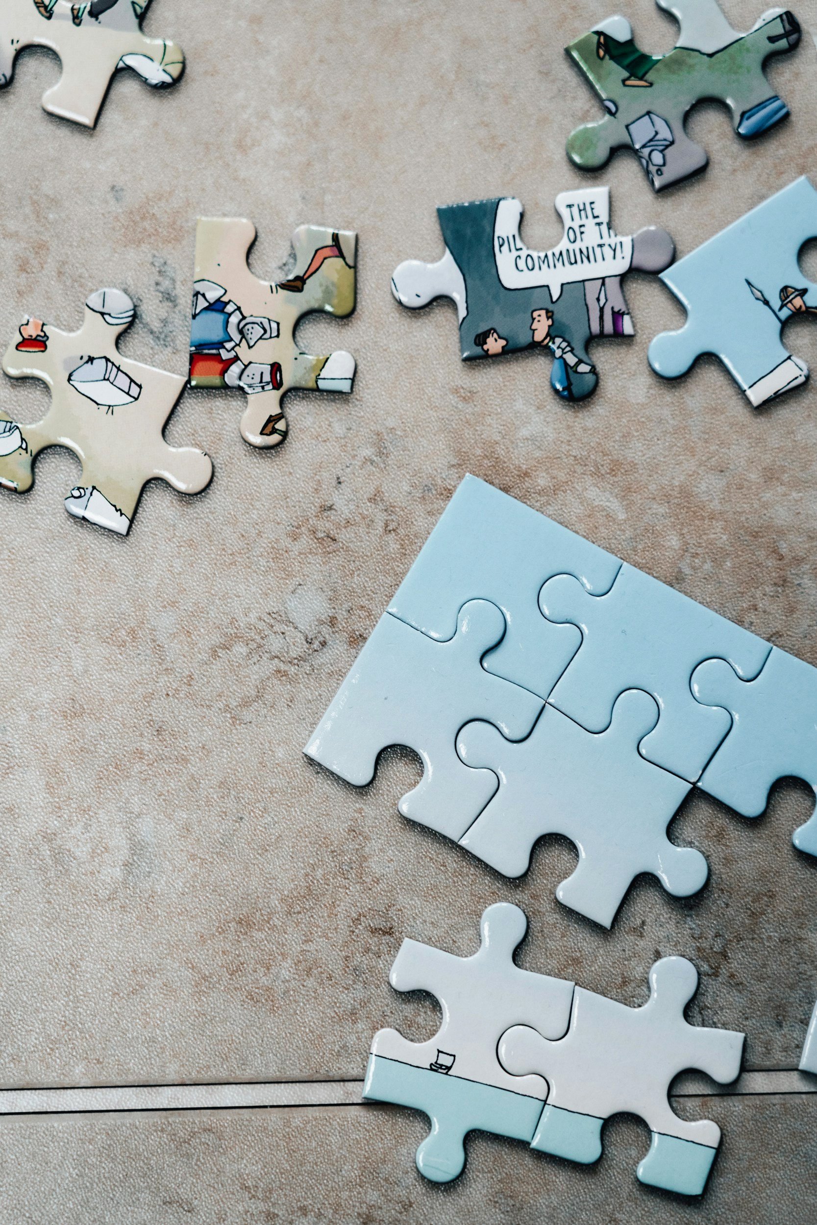 Several assembled and unassembled puzzle pieces on a beige surface,