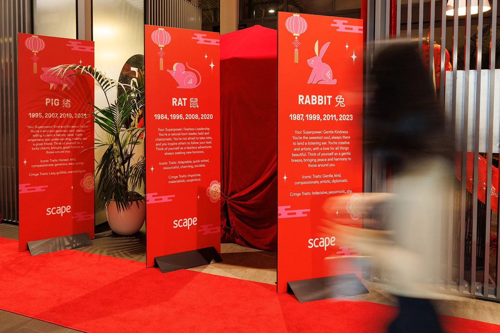 Chinese new year signs with women in foreground blurred walking by