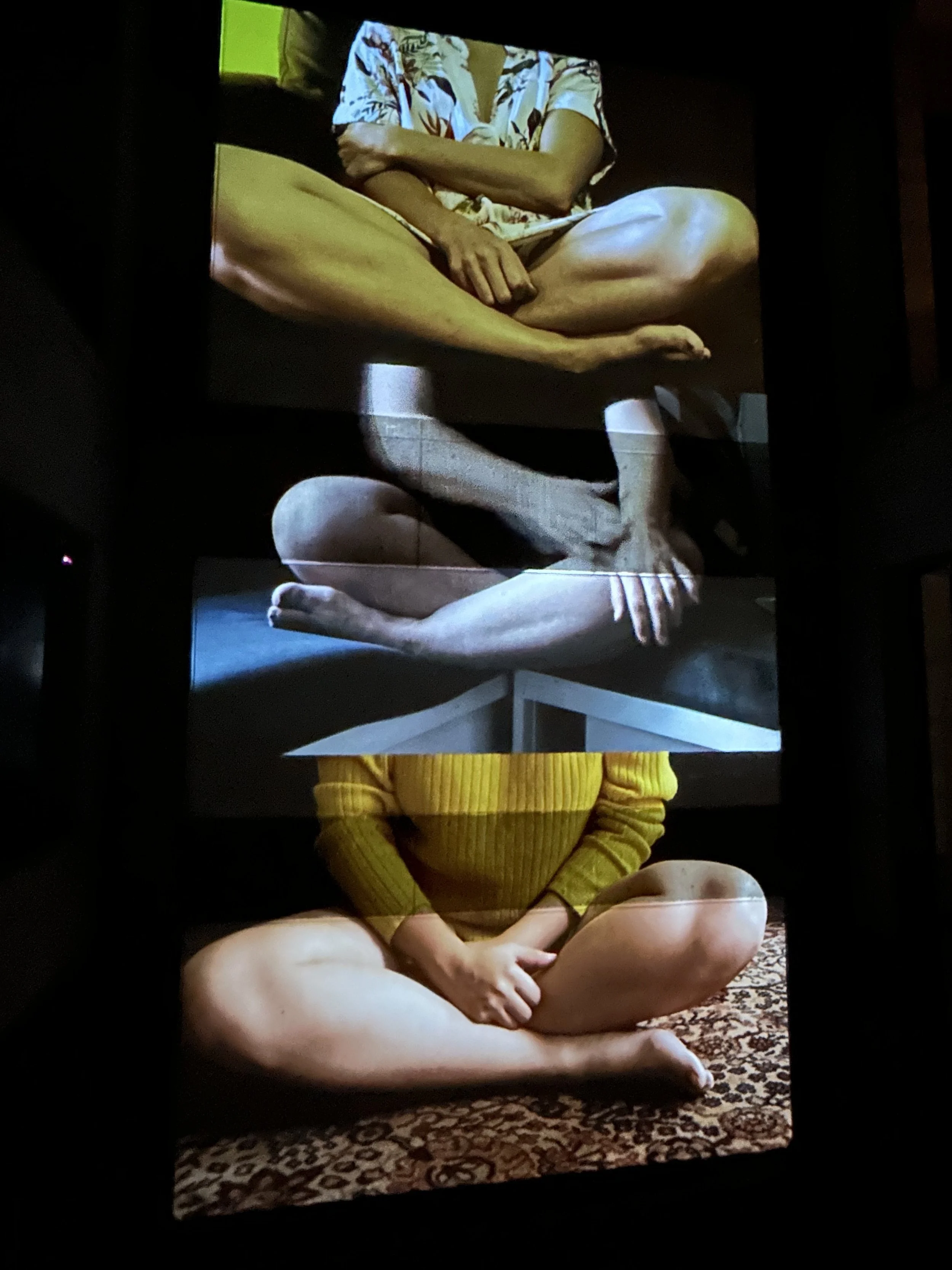 Proyección de imágenes superpuestas mostrando personas sentadas con las piernas cruzadas. Se ven diferentes posiciones de manos, brazos y ropa, como una camisa estampada y un suéter amarillo. La imagen tiene un efecto artístico de collage.