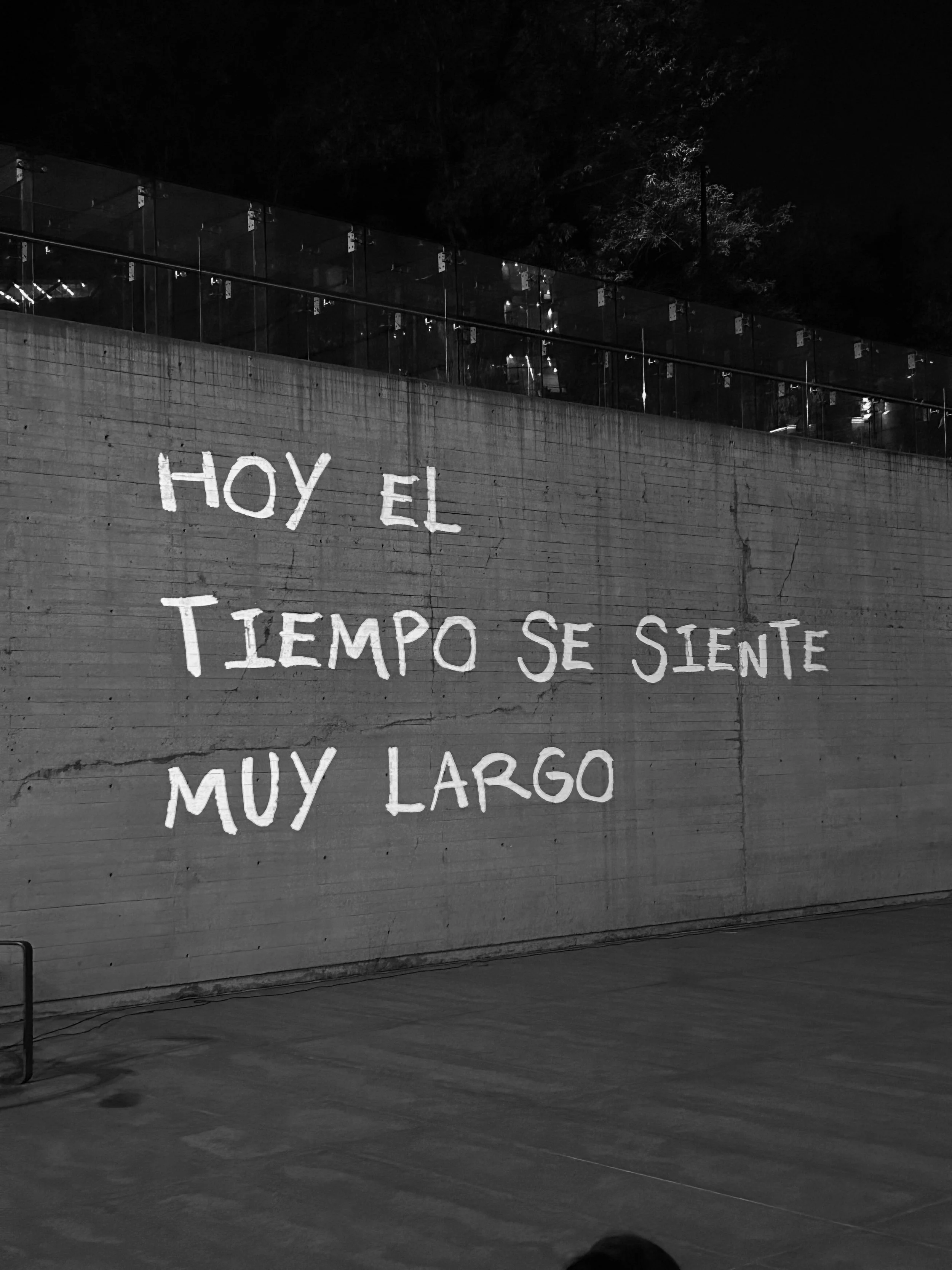 Grafiti en una pared de concreto que dice: 'Hoy el tiempo se siente muy largo'.