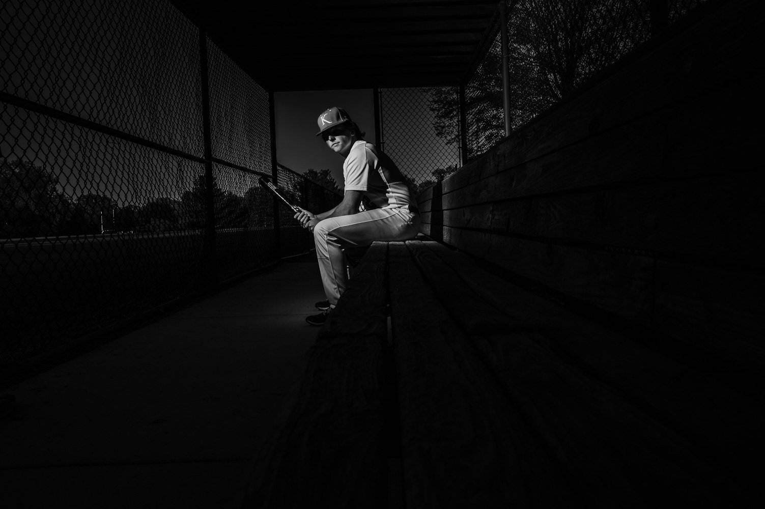 black and white senior photo at a baseball field.jpg
