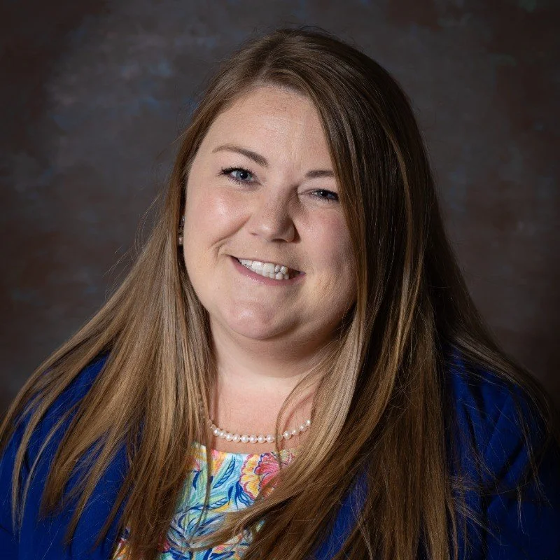 Young female smiling for a headshot in pearls