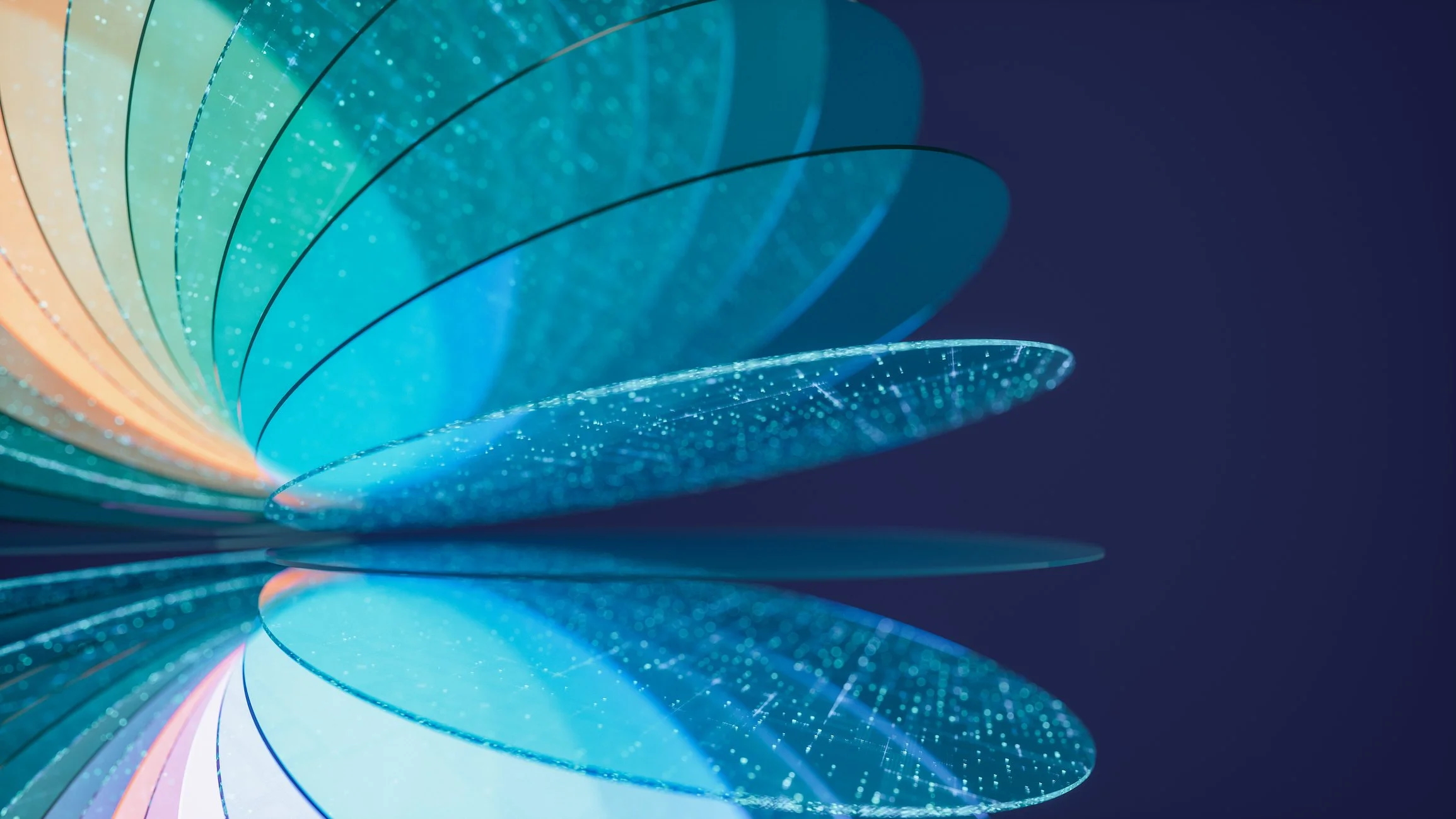 Close-up of abstract, curved, rainbow-colored glass or plastic sheets with glittery details, arranged in a layered, spiraling pattern against a dark background.