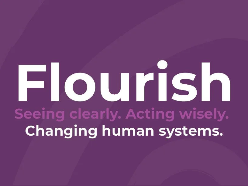 Purple background with the word 'Flourish' in large white letters, and the text 'Seeing clearly. Acting wisely.' in smaller purple font, and 'Changing human systems.' in white.