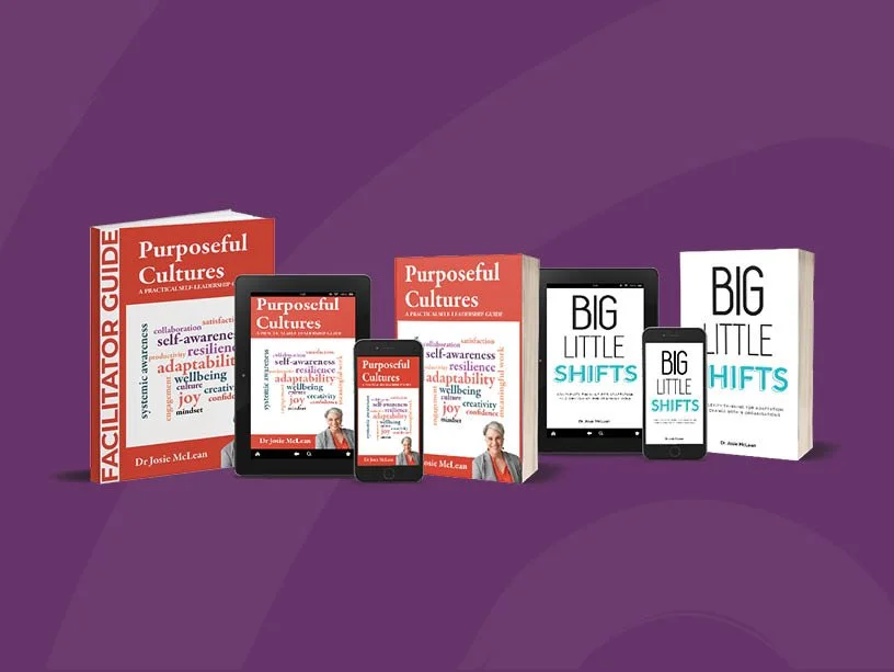 Books and digital devices displaying the titles 'Purposeful Cultures' and 'BIG LITTLE SHIFTS' by Dr. Josie McLean