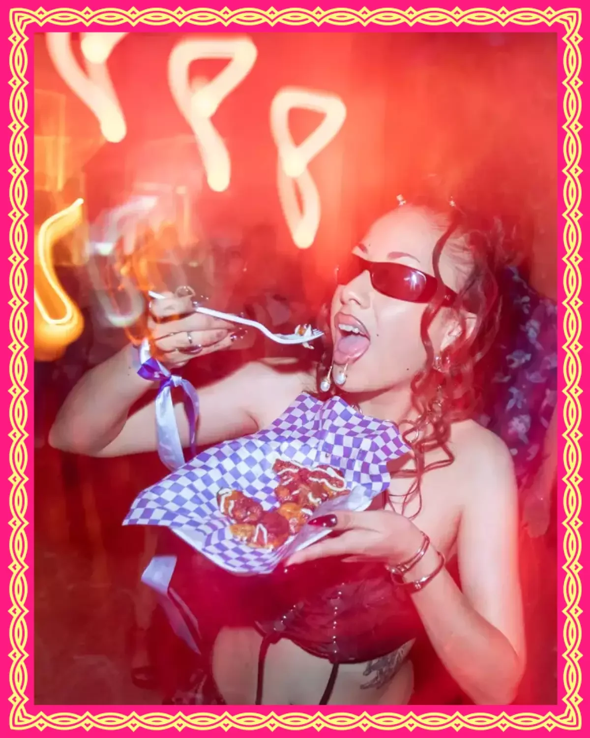 Joven con gafas de sol, chupando y comiendo pizza en un ambiente festivo con luces de neón y borde decorativo rosa y amarillo.