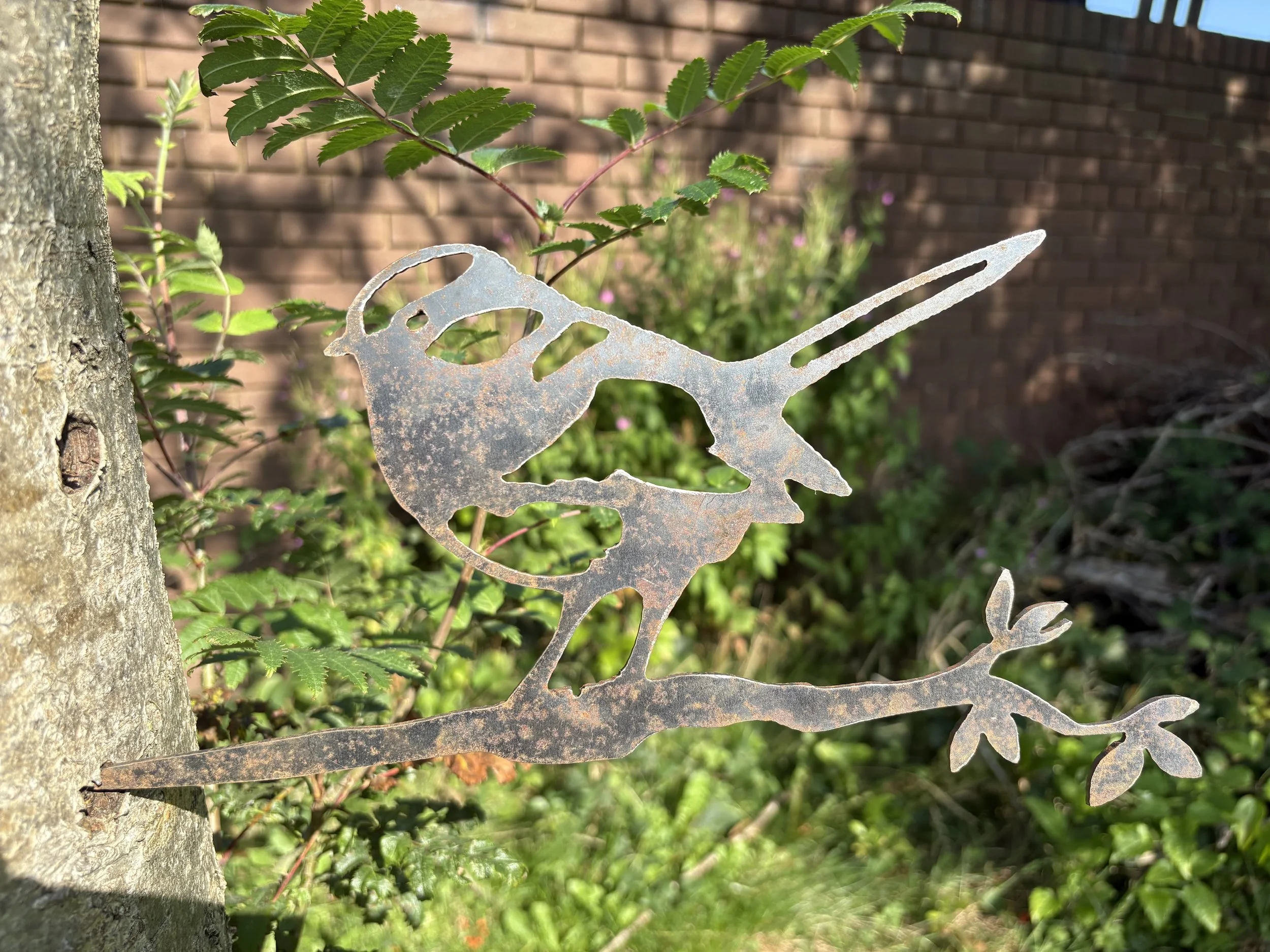 Blue tit metal ornament on twig, crafted from durable steel—rusts over time and adds birdlike whimsy to outdoor spaces effortlessly.