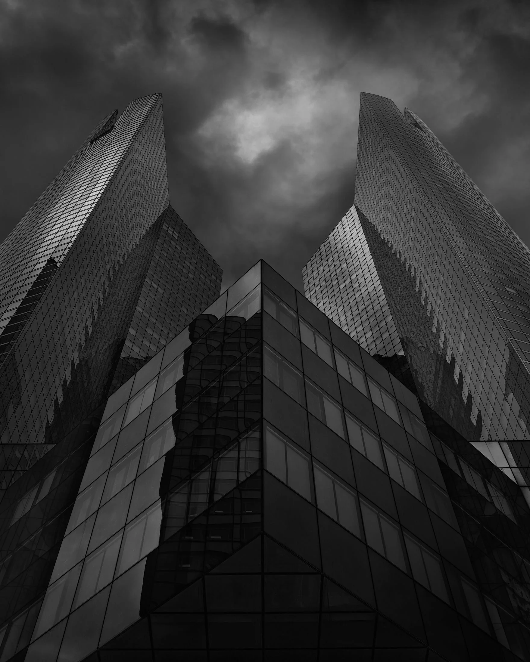 [architecture] [europe] [paris] [blackandwhite] Société Generale towers La Défense upward monochrome, two dark glass slab towers flanking a low angular podium. Architectural Photography by Jim Scott.