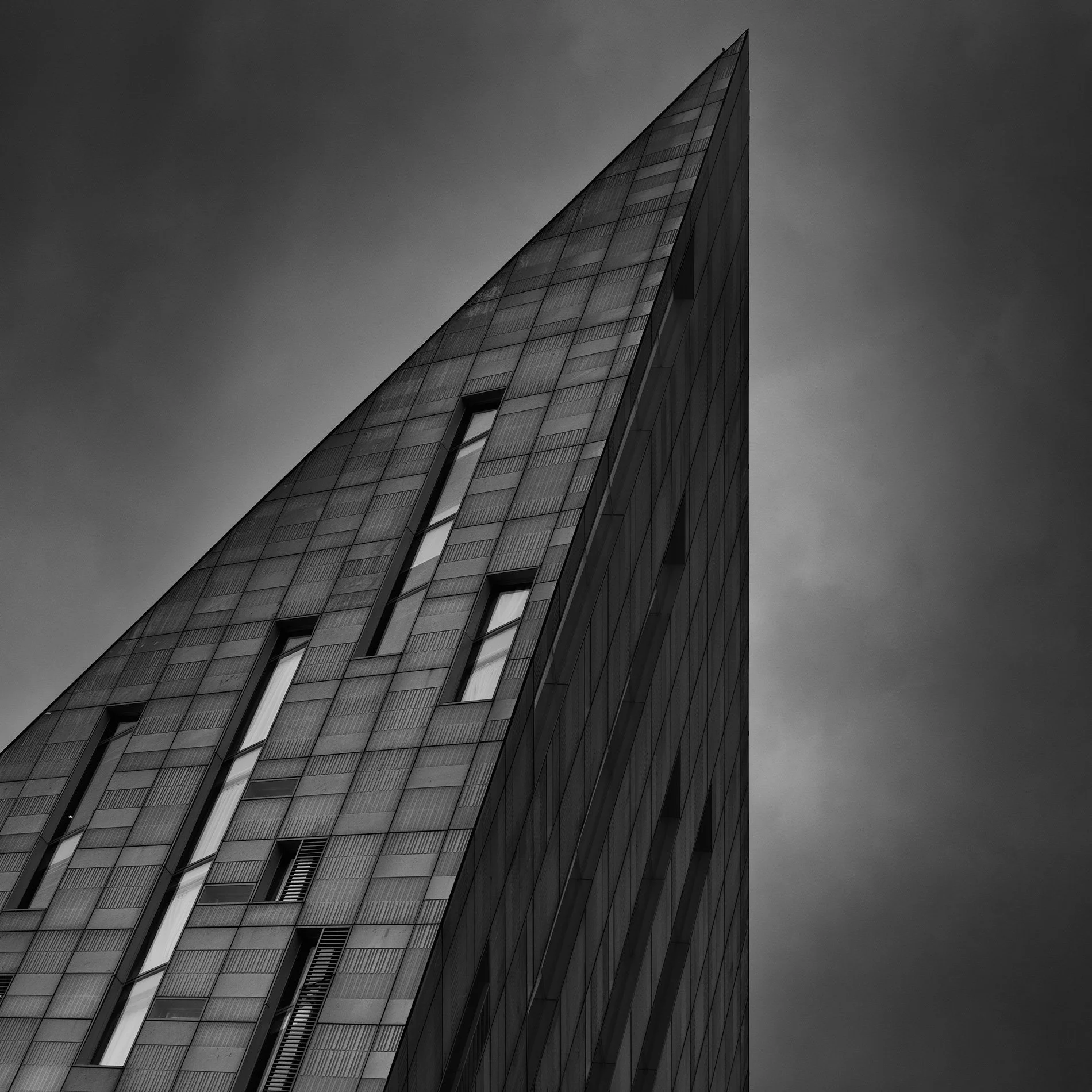 Contemporary geometric architecture in Shoreditch, London: A dramatic monochromatic study of the Montcalm East hotel on City Road, designed by Squire & Partners. This close-up architectural photograph captures the building’s iconic diamond-shaped pro