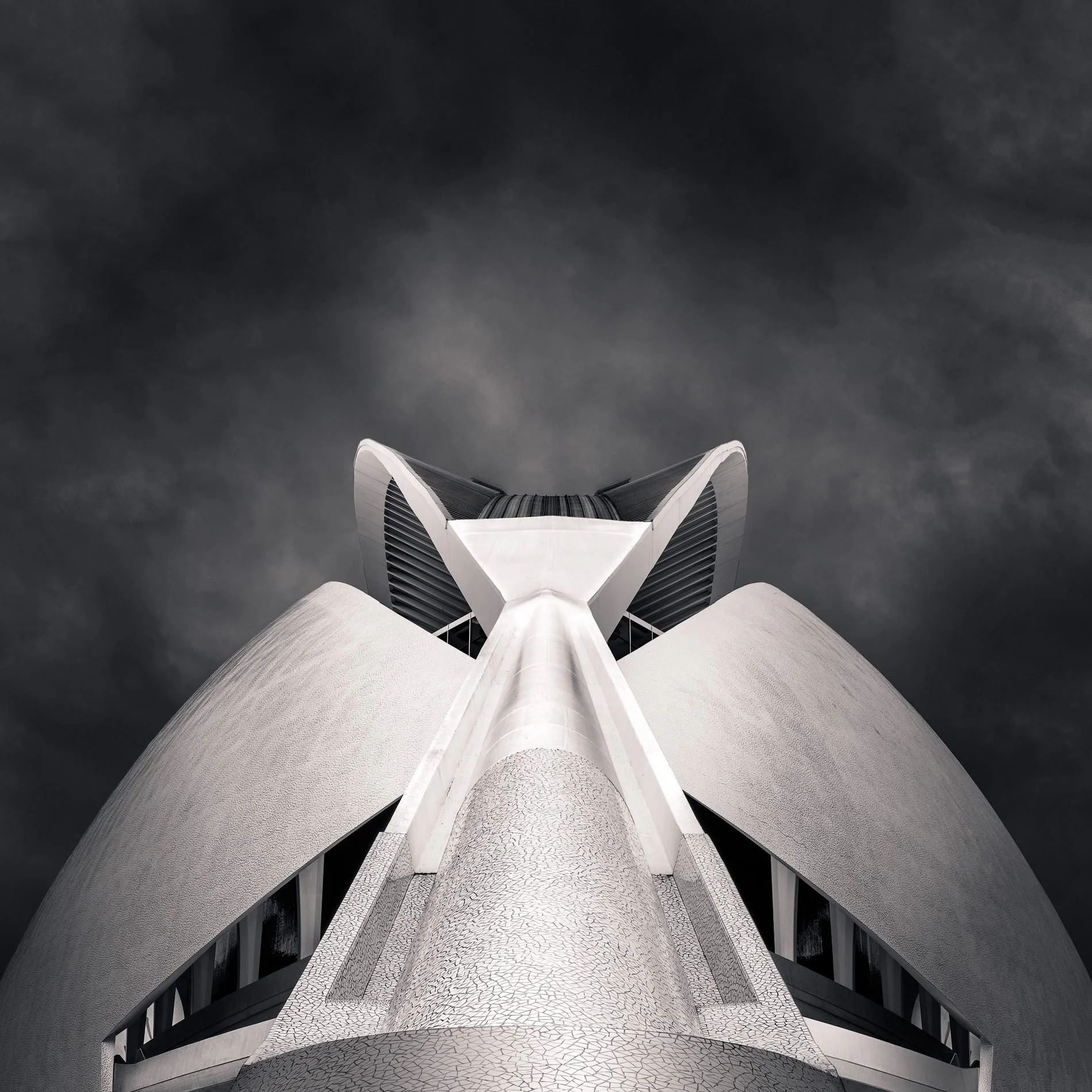 [architecture] [europe] [valencia] [blackandwhite] [square] Palau de les Arts Valencia crown from below, bifurcated white shell ears rising against a brooding dark storm sky. Architectural Photography by Jim Scott.
