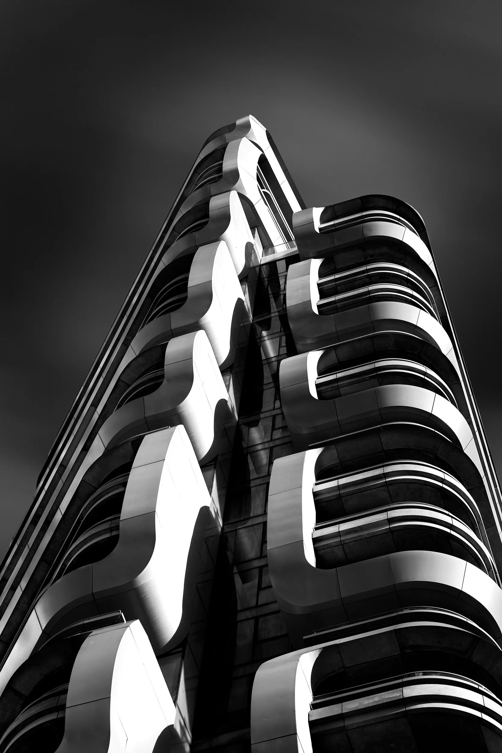 [architecture] [uk] [london] [blackandwhite] Canaletto Tower Islington London upward monochrome, undulating white wave balcony fins and dark glass to a fine apex. Architectural Photography by Jim Scott.