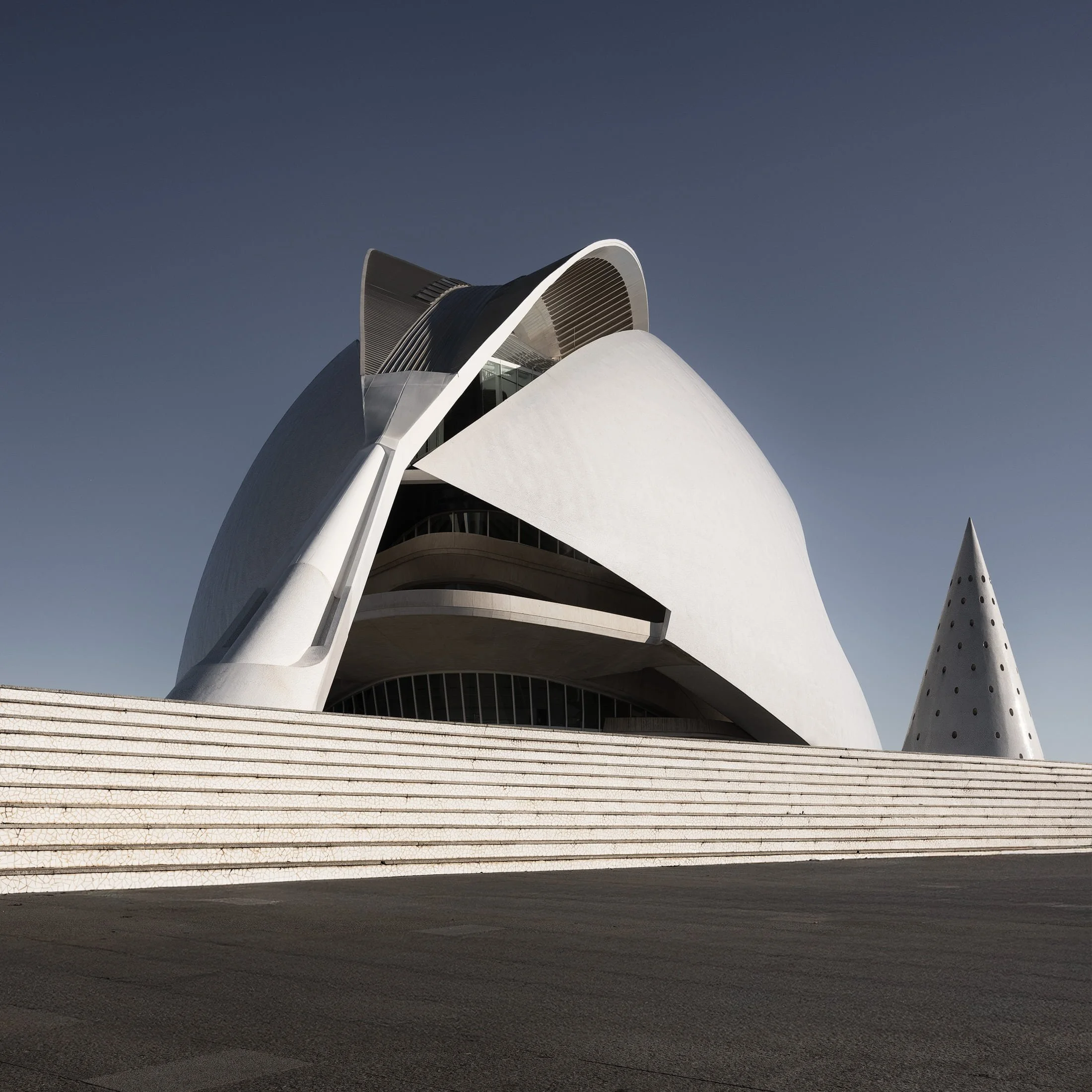 [architecture] [europe] [valencia] [colour] [square] Calatrava's Palau de les Arts Valencia, sculptural white shell form and layered concrete terraces under deep blue sky. Architectural Photography by Jim Scott.