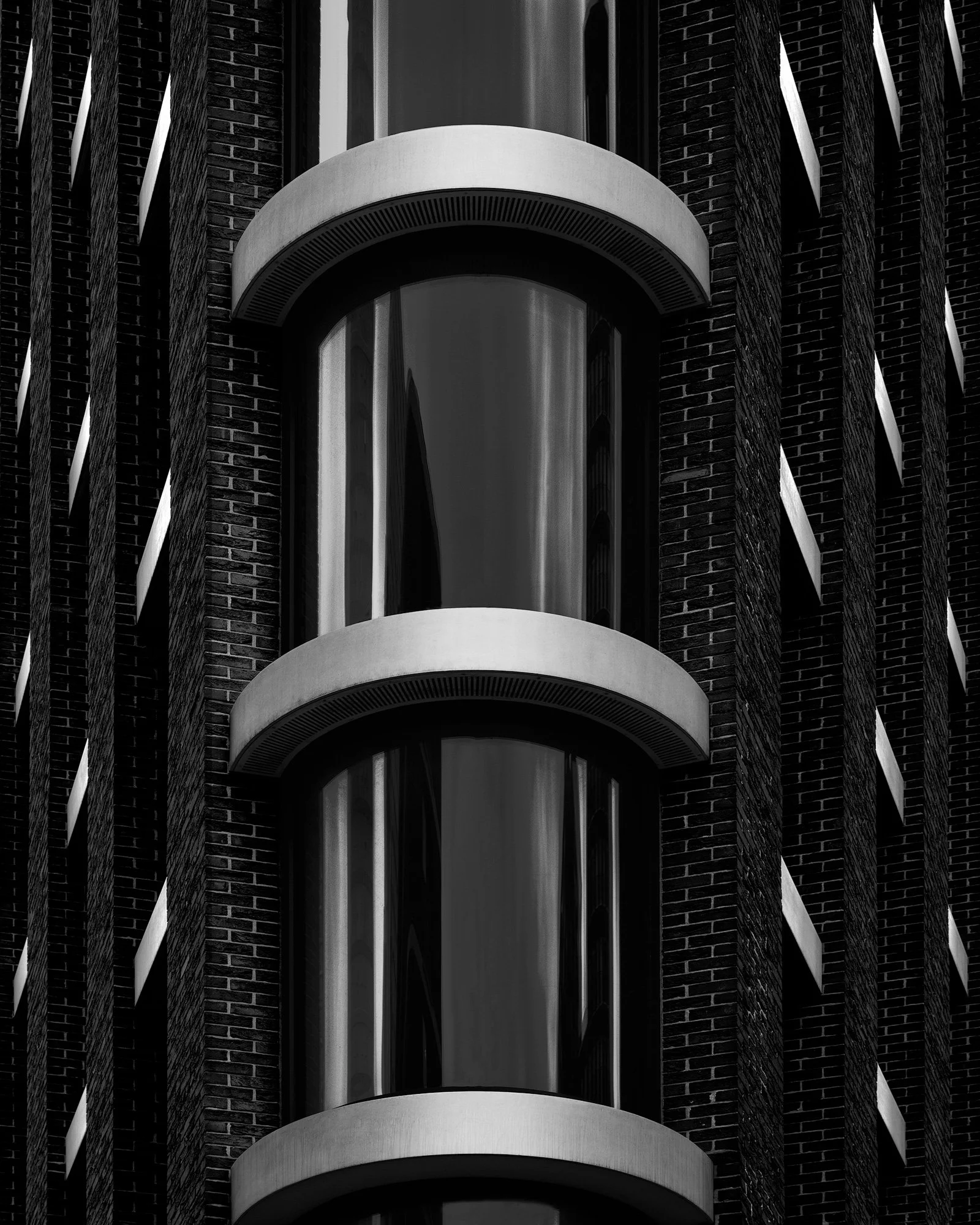 [architecture] [uk] [london] [blackandwhite] [abstract Urbanest Vauxhall London abstract B&W, stacked glazed cylinder balconies with steel rings rising between dark brick Architectural Photography by Jim Scott.