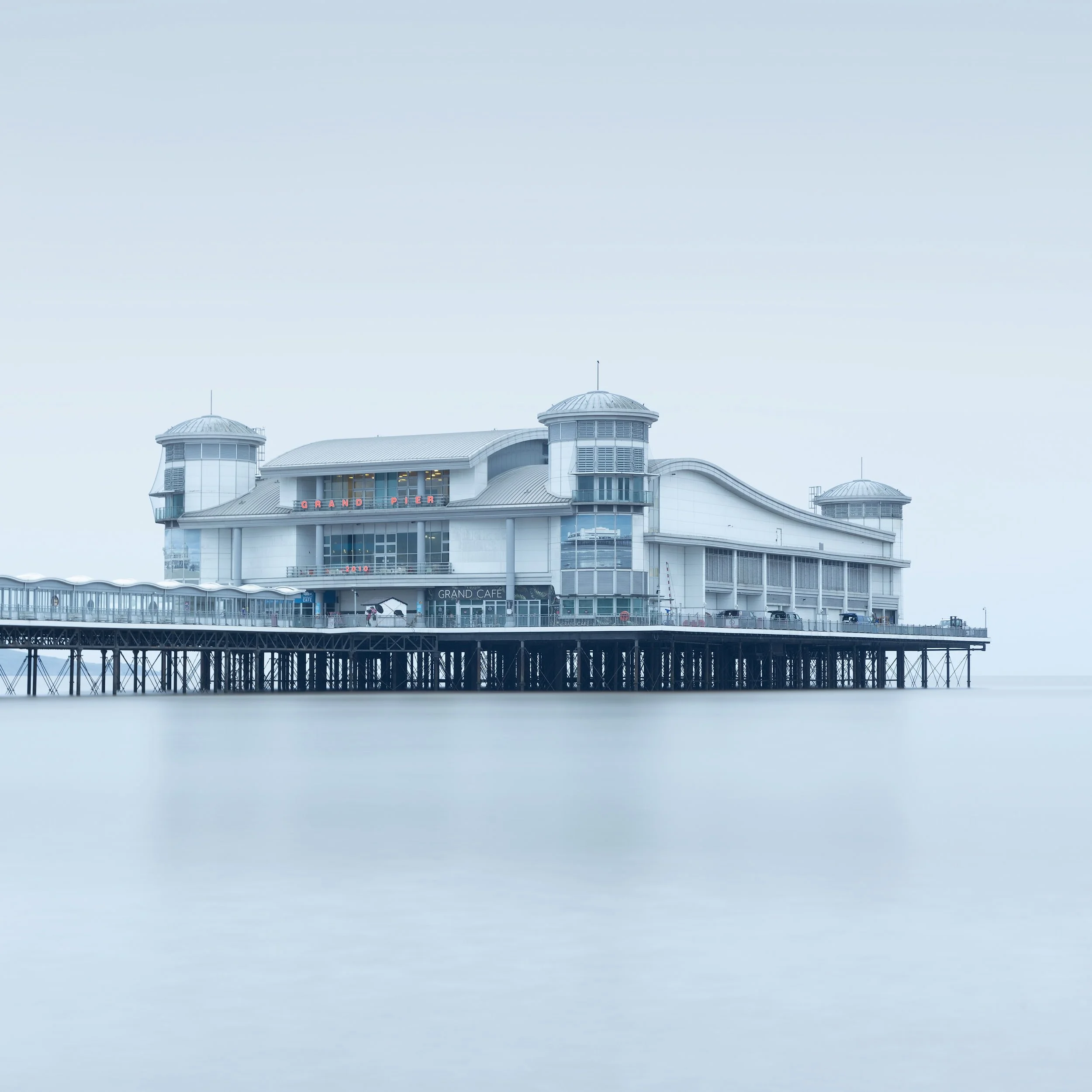 [architecture] [uk] [westonsupermare] [colour] [square] Grand Pier Weston-super-Mare, Art Deco pavilion floating serenely above a silken pale blue misty sea. Architectural Photography by Jim Scott.