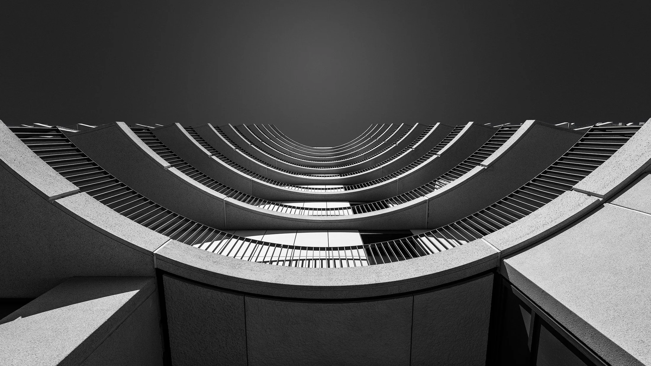 [architecture] [uk] [london] [blackandwhite] [panoramic] Delphic House King's Cross London upward abstract, stacked curved white concrete balcony bands forming concentric arcs. Architectural Photography by Jim Scott.