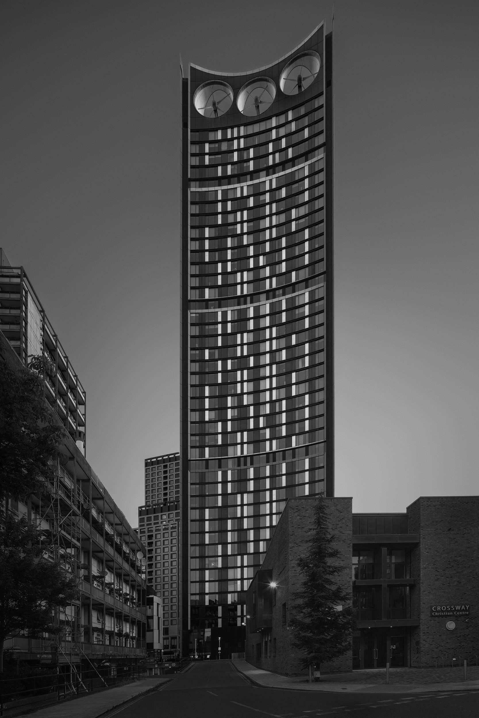Sustainable skyscraper architecture in London: Strata SE1 (The Razor) in Elephant and Castle, designed by BFLS. A low-angle black and white photograph highlighting the building’s distinct elliptical shape and the three integrated wind turbines at its
