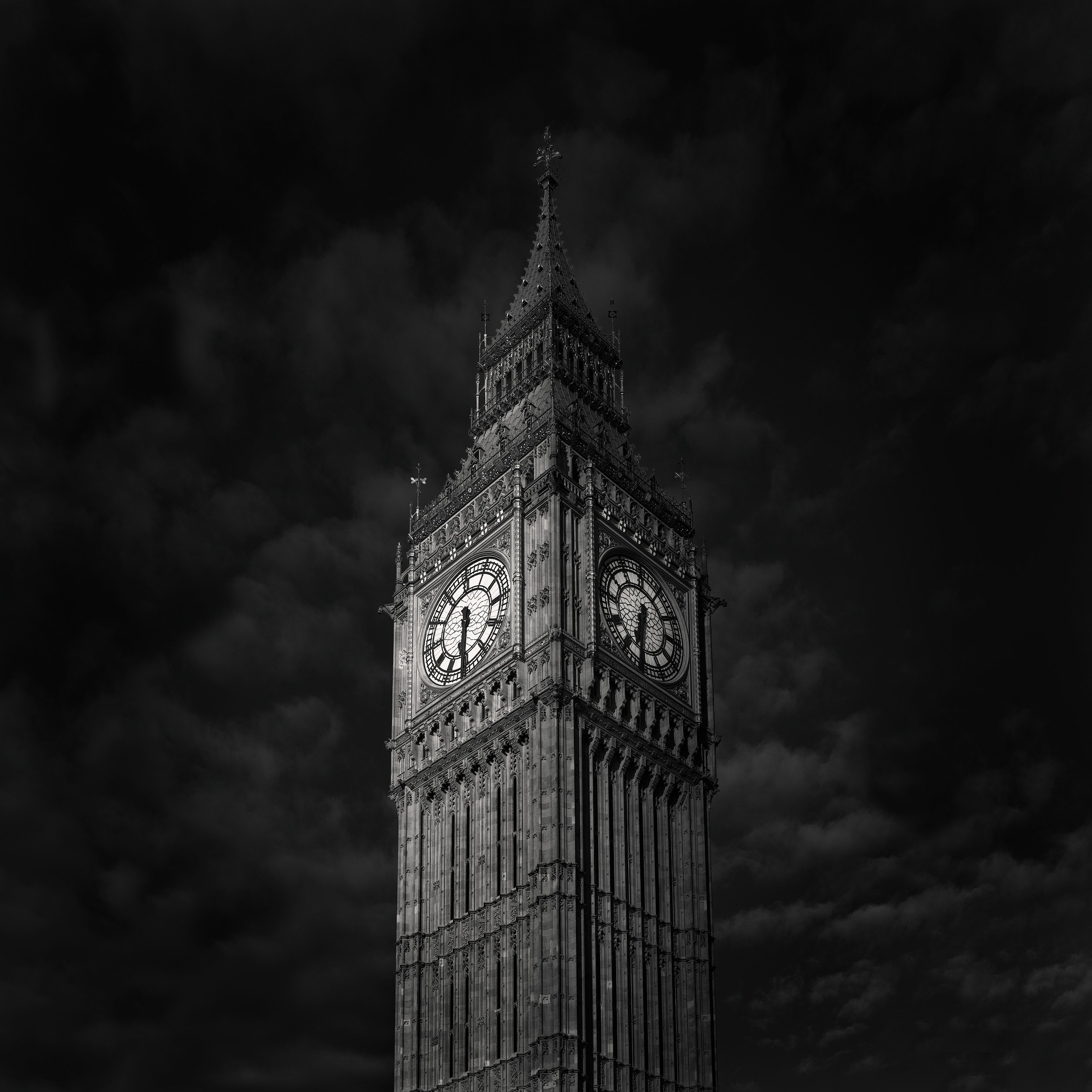 [architecture] [uk] [london] [blackandwhite] [square] Elizabeth Tower Big Ben London, Gothic Victorian clock tower with illuminated dials set against a dark cloudy sky. Architectural Photography by Jim Scott.