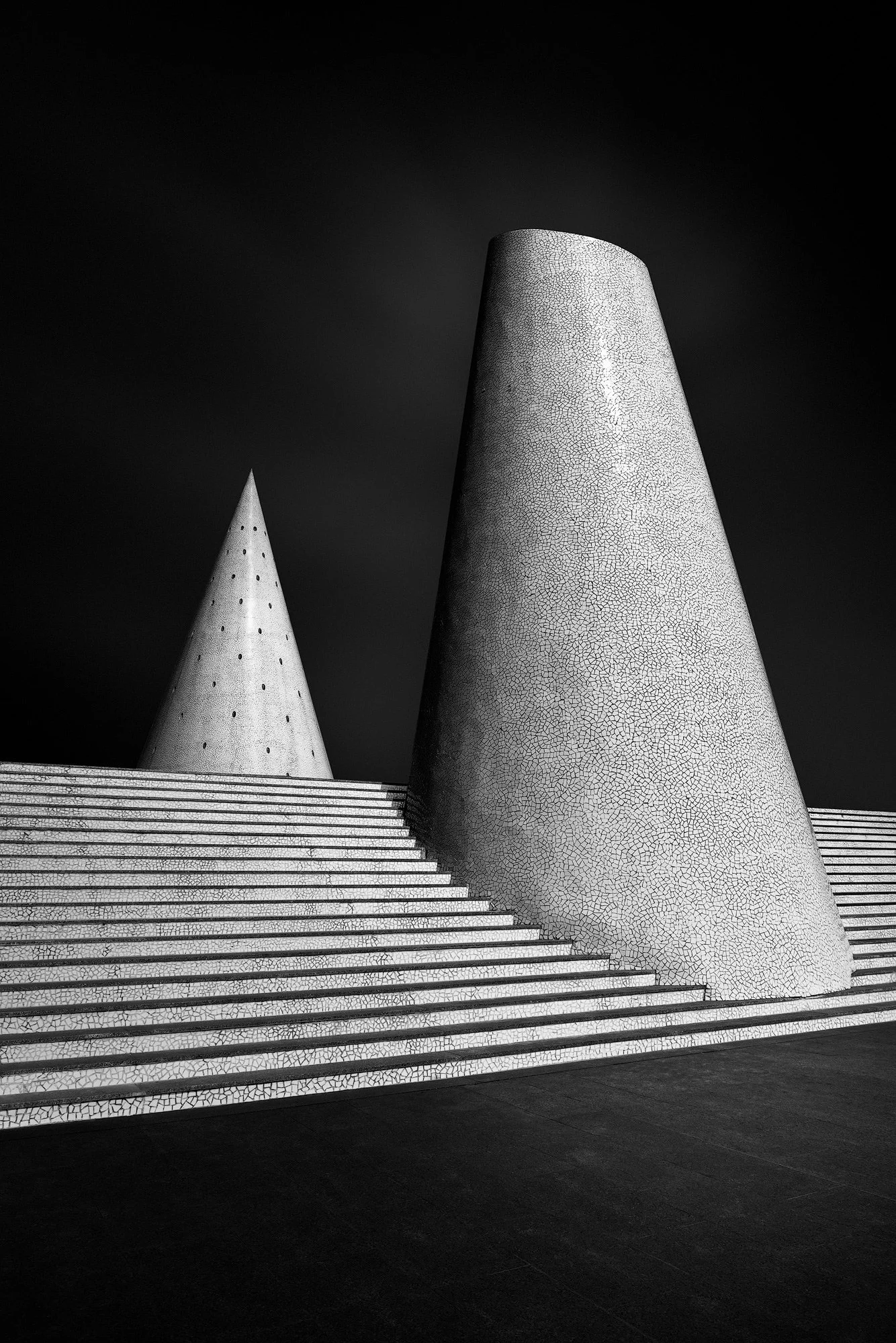 [architecture] [europe] [valencia] [blackandwhite] Calatrava's ceramic cone chimneys Valencia, sharp perforated spire and truncated tower with trencadís mosaic rising. Architectural Photography by Jim Scott.