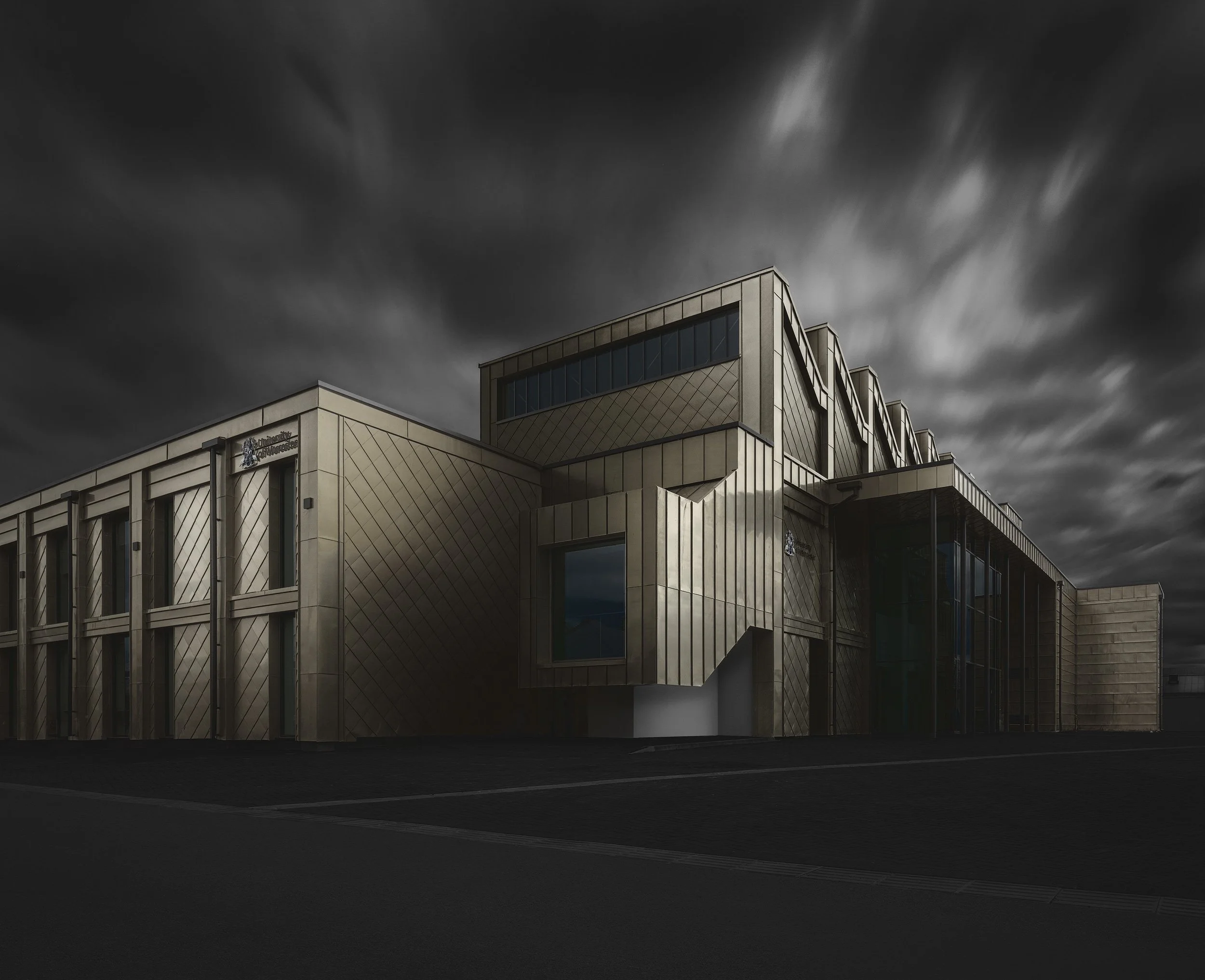 [architecture] [uk] [worcester] [colour] Elizabeth Garrett Anderson Building Worcester, golden zinc cladding catching light under a swirling stormy sky. Architectural Photography by Jim Scott.