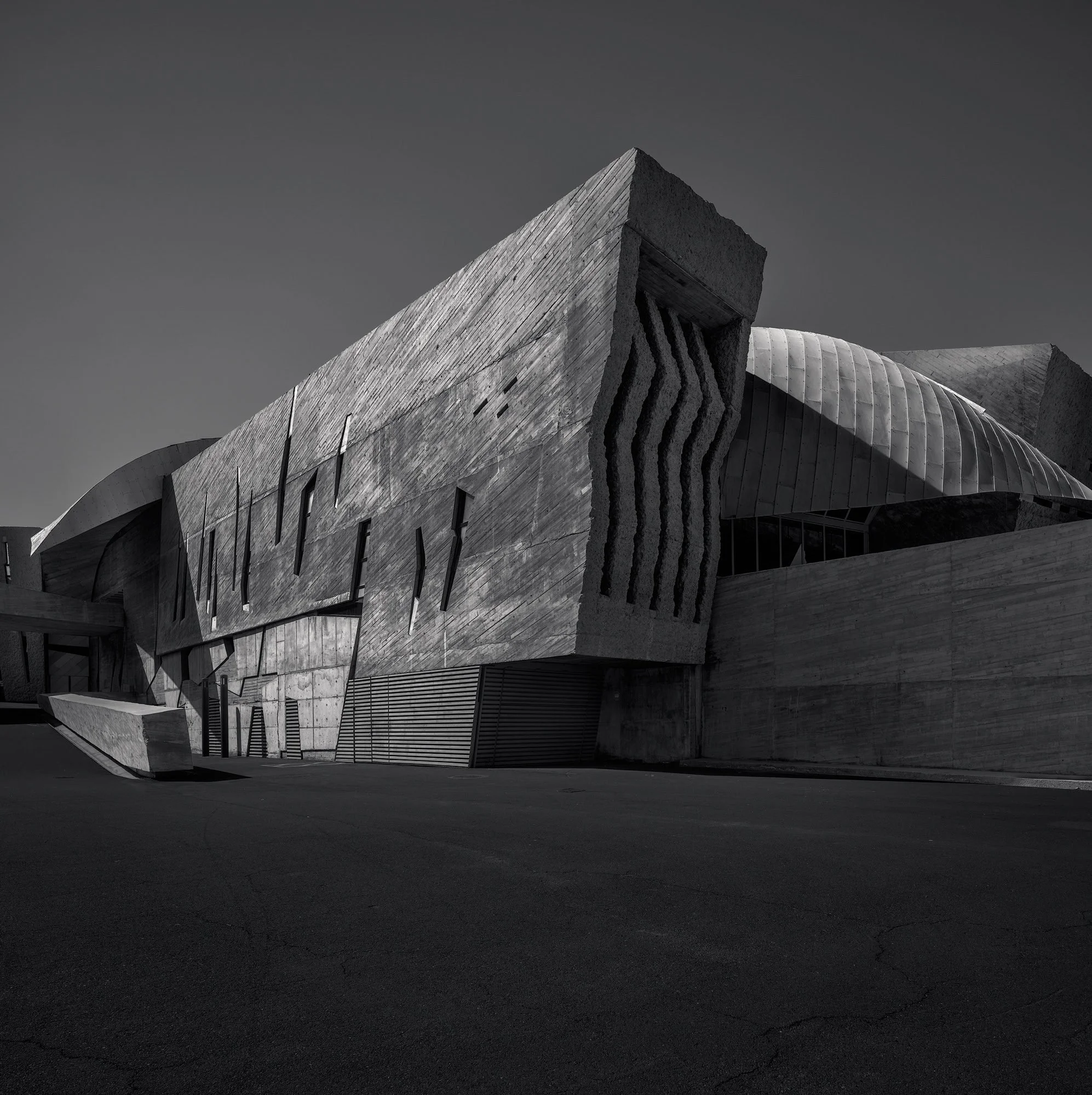 [architecture] [europe] [costaadeje] [blackandwhite] [square] Magma Arte y Congresos Tenerife B&W, volcanic lava-stone angular deconstructivist forms under a bright clear sky. Architectural Photography by Jim Scott.