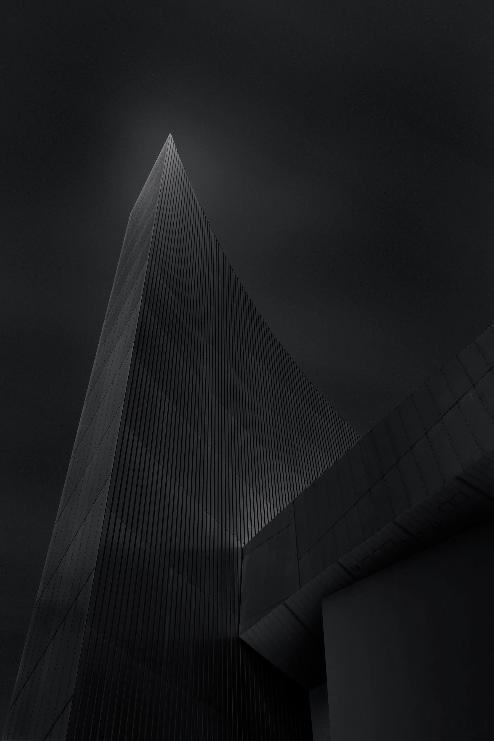 Deconstructivist architecture in Salford: The Imperial War Museum North (IWM North) designed by Daniel Libeskind. A high-contrast black and white photograph of the 55-metre vertical 'Air Shard' tower, showcasing its dramatic metallic angles and skele