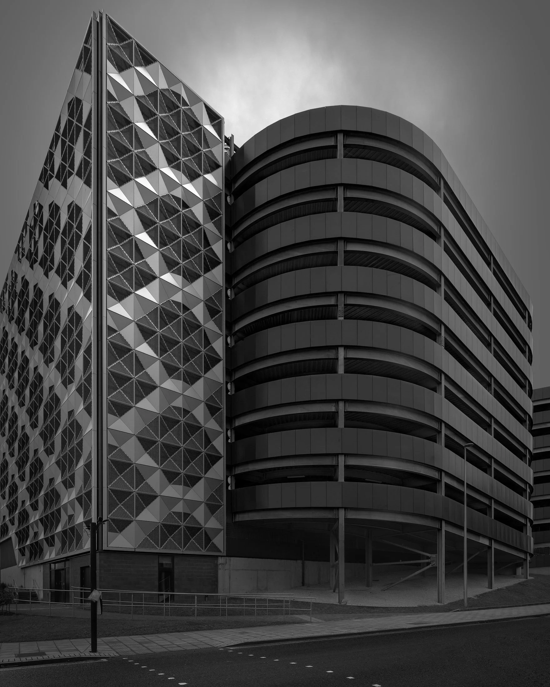 [architecture] [uk] [gateshead] [blackandwhite] Gateshead Hawks car park, diamond mesh facade contrasting curved concrete levels, bold geometric monochrome. Architectural Photography by Jim Scott.