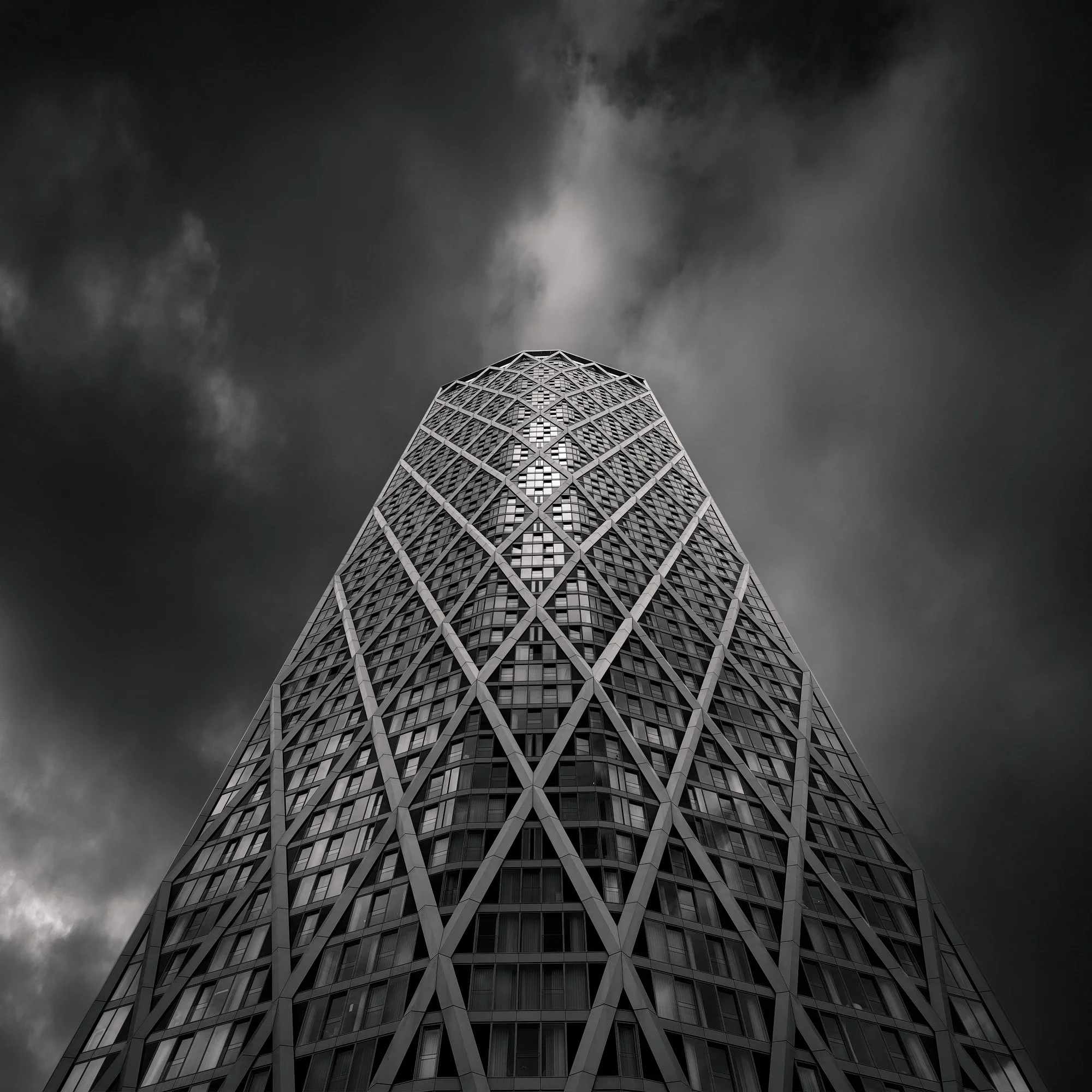 Contemporary skyscraper architecture in Canary Wharf, London: A dramatic low-angle study of the Newfoundland tower, designed by Horden Cherry Lee Architects. This monochromatic architectural photograph highlights the building's innovative external di