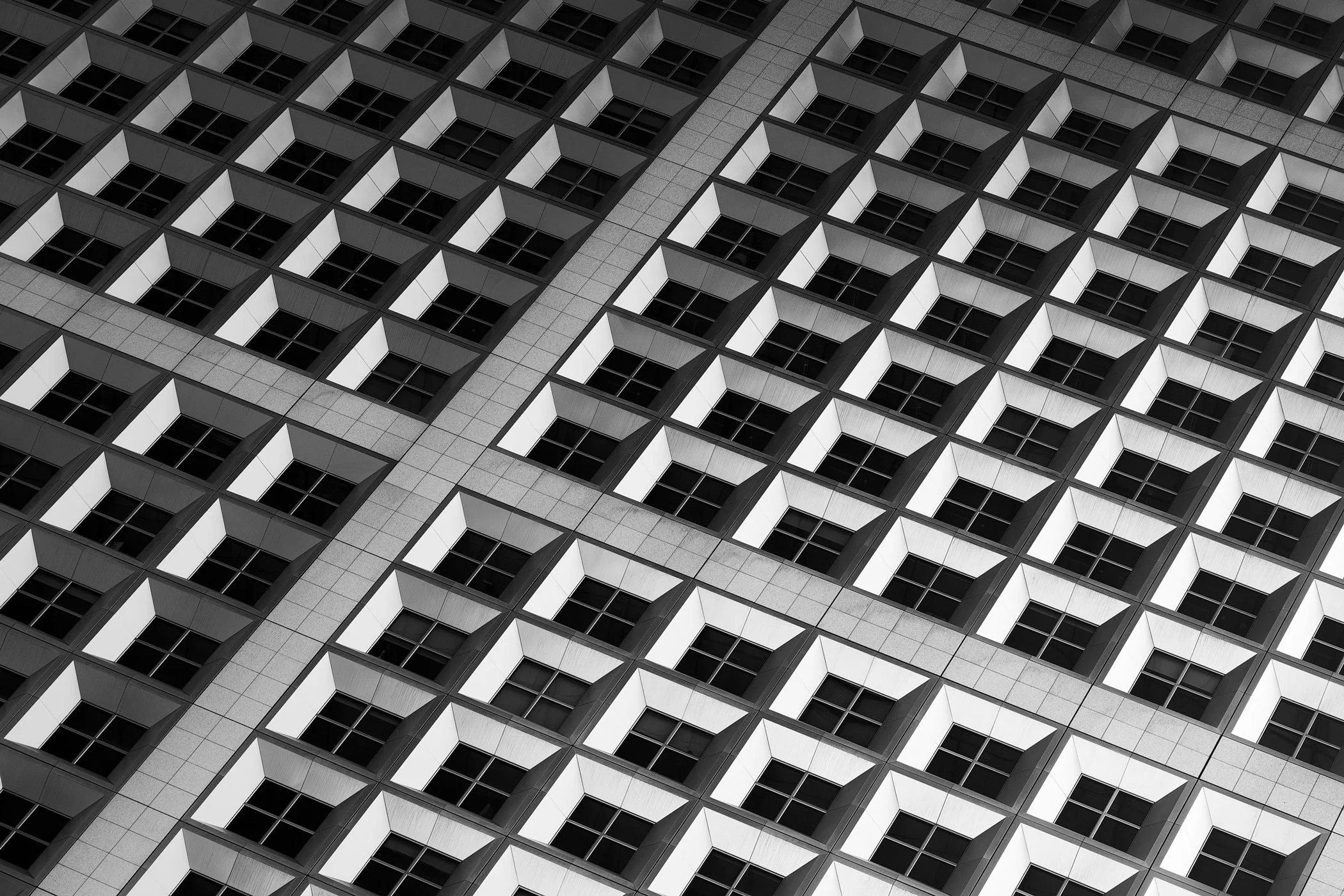 [architecture] [europe] [paris] [blackandwhite] [abstract] Grande Arche La Défense Paris, repeating angular window grid facade detail, abstract light and shadow pattern, black and white. Architectural Photography by Jim Scott.