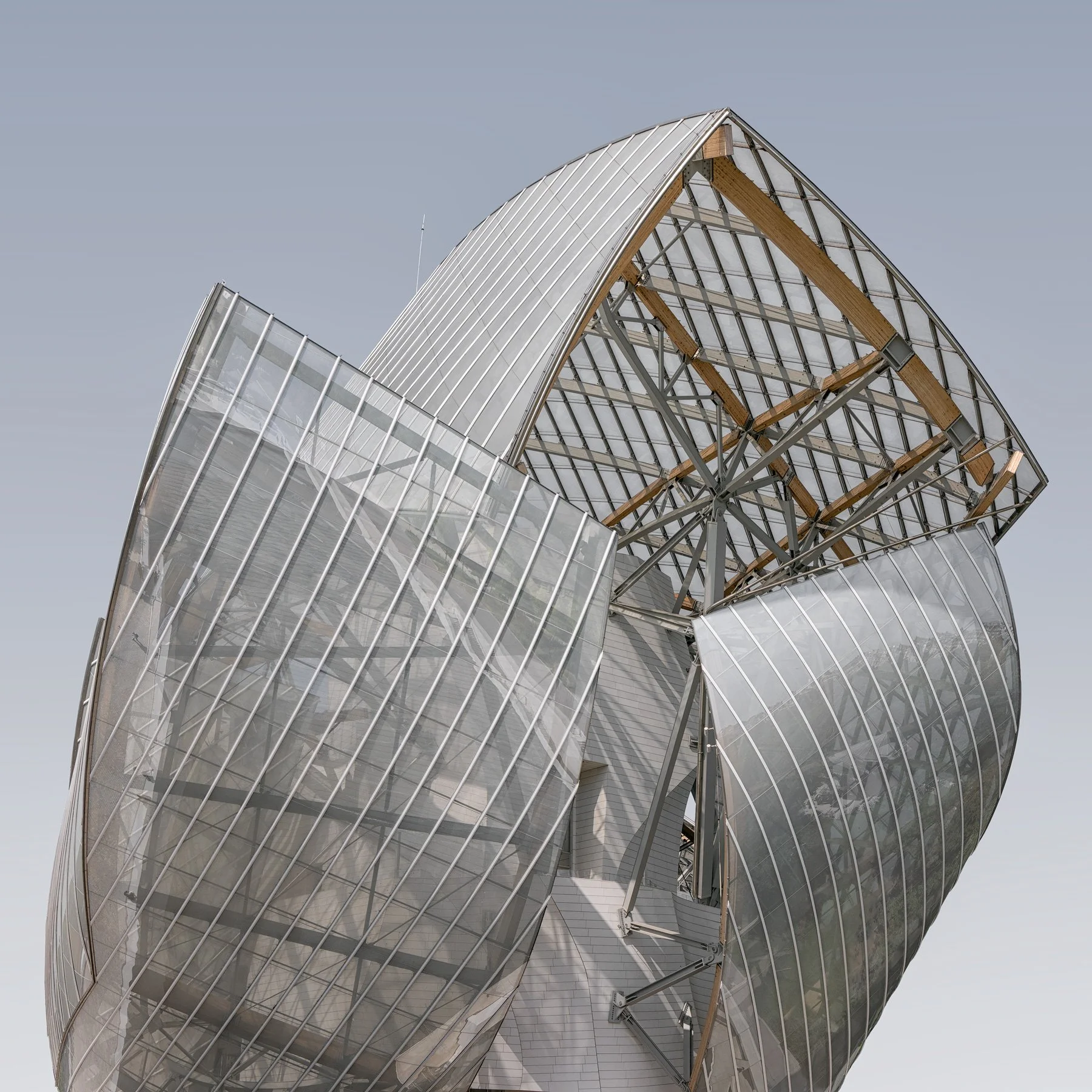 Contemporary  architecture in Paris, France: A high-key study of the Foundation Louis Vuitton, designed by Frank Gehry. This architectural photograph highlights the building's iconic glass sails and complex timber-and-steel support structure. Utilisi