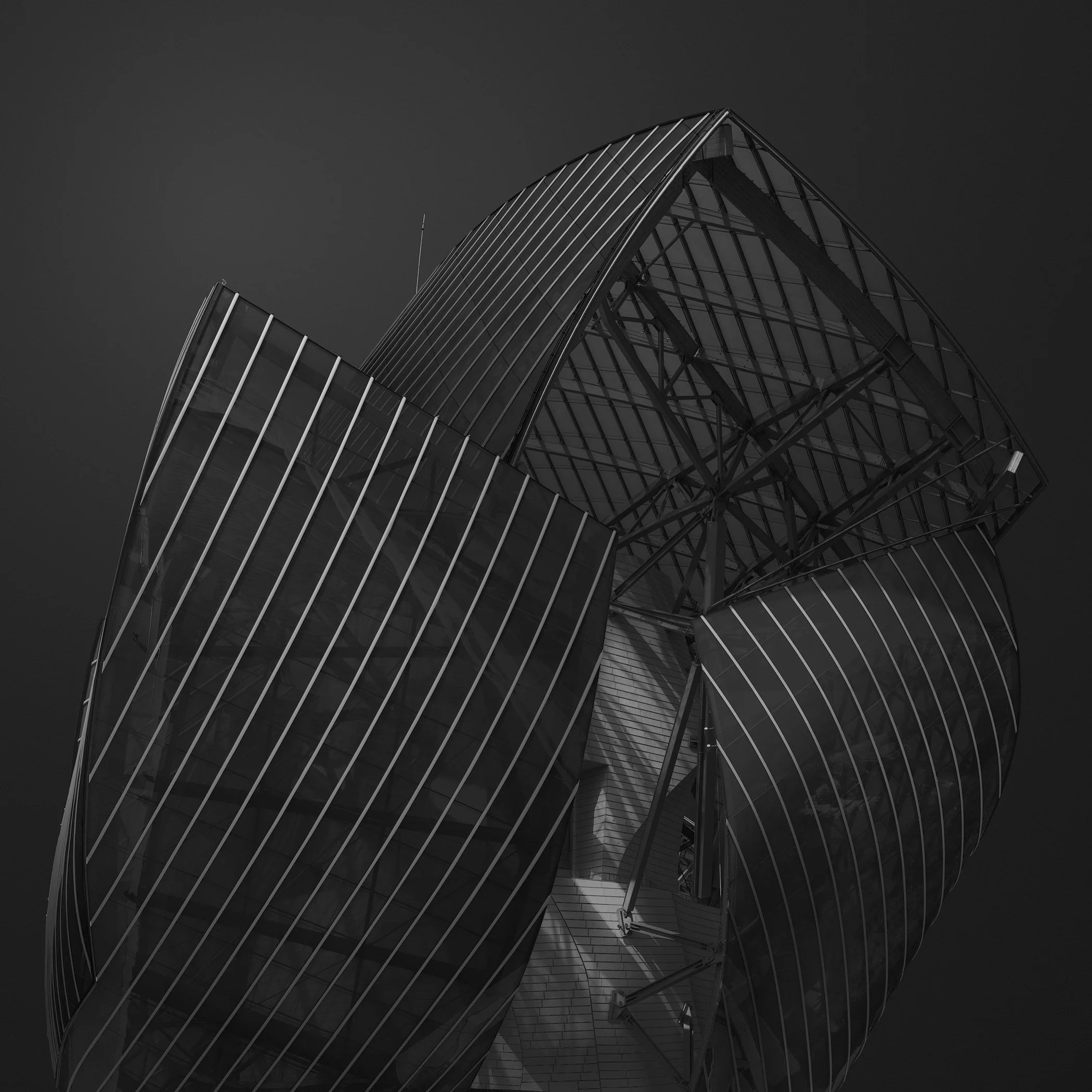 [architecture] [europe] [paris] [blackandwhite] [square] Fondation Louis Vuitton Paris, Frank Gehry billowing glass sail canopies, deconstructivist sculptural form, dark black and white. Architectural Photography by Jim Scott.