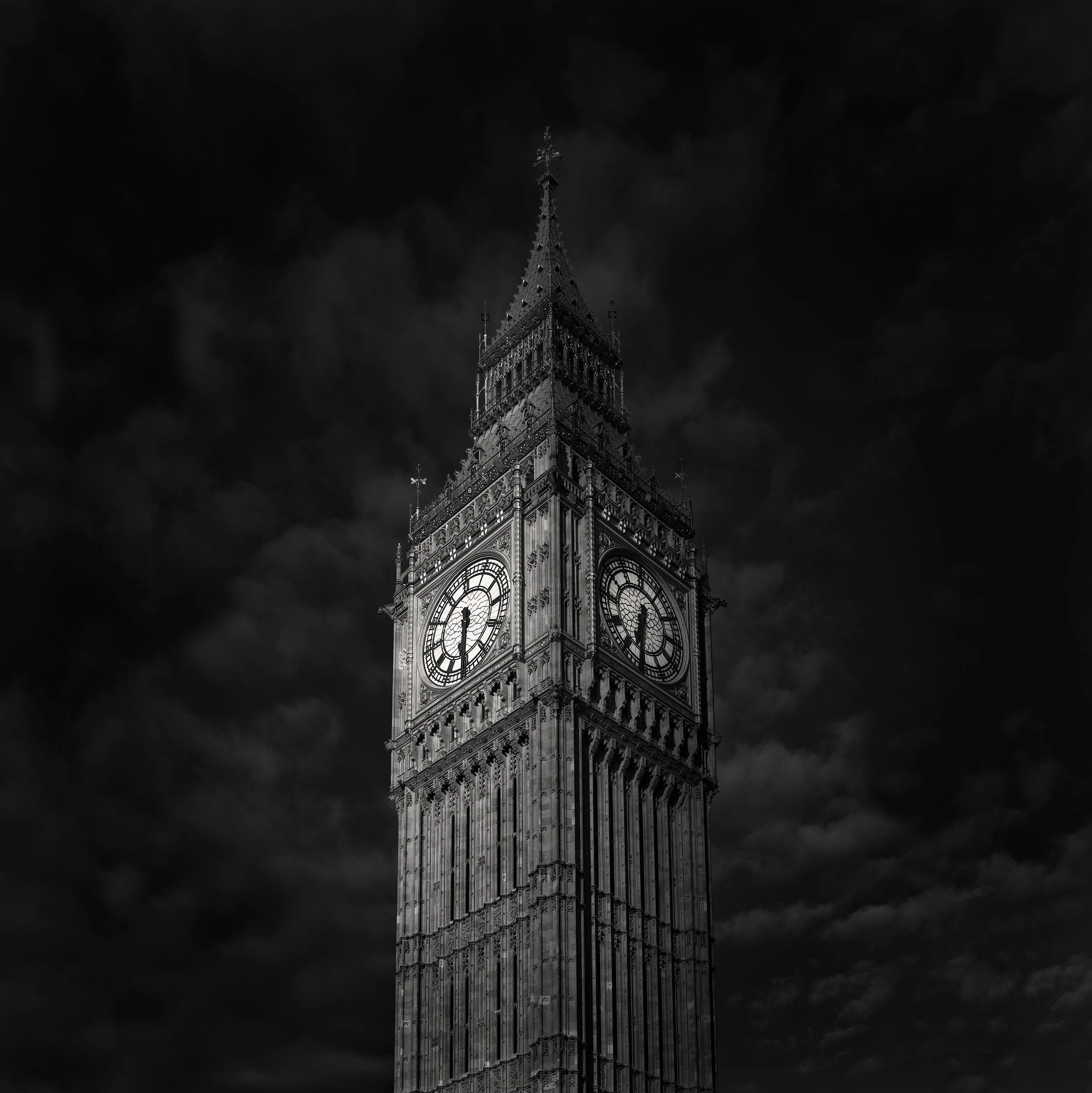 Gothic Revival architecture in London: The Elizabeth Tower (Big Ben) at the Palace of Westminster, designed by Augustus Pugin and Charles Barry. A high-contrast black and white architectural study highlighting the intricate stone carvings and the glo