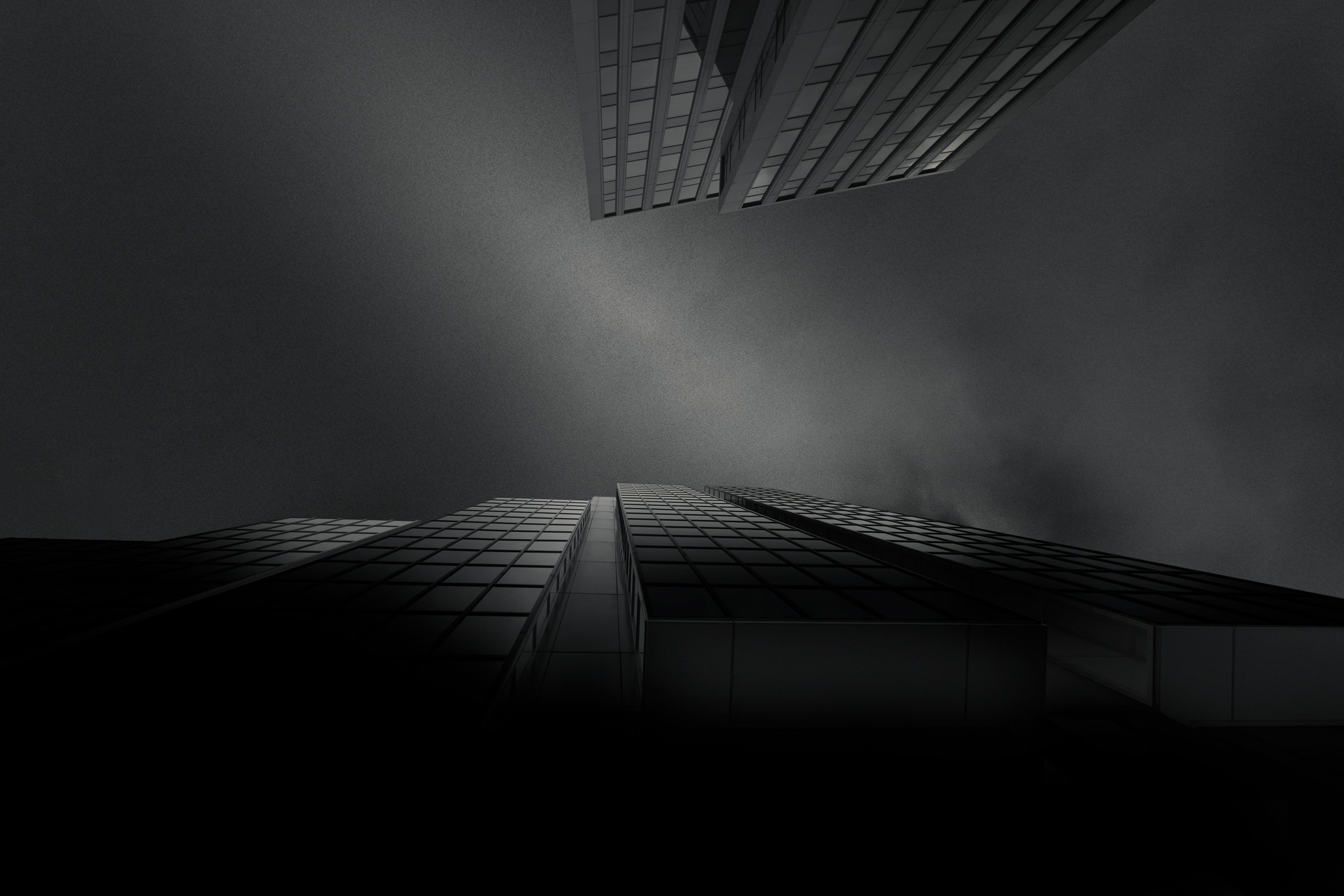 [architecture] [uk] [glasgow] [blackandwhite] Dark glass office tower on St Vincent Street Glasgow from below, receding grid facade fading into a moody glowing sky. Architectural Photography by Jim Scott.