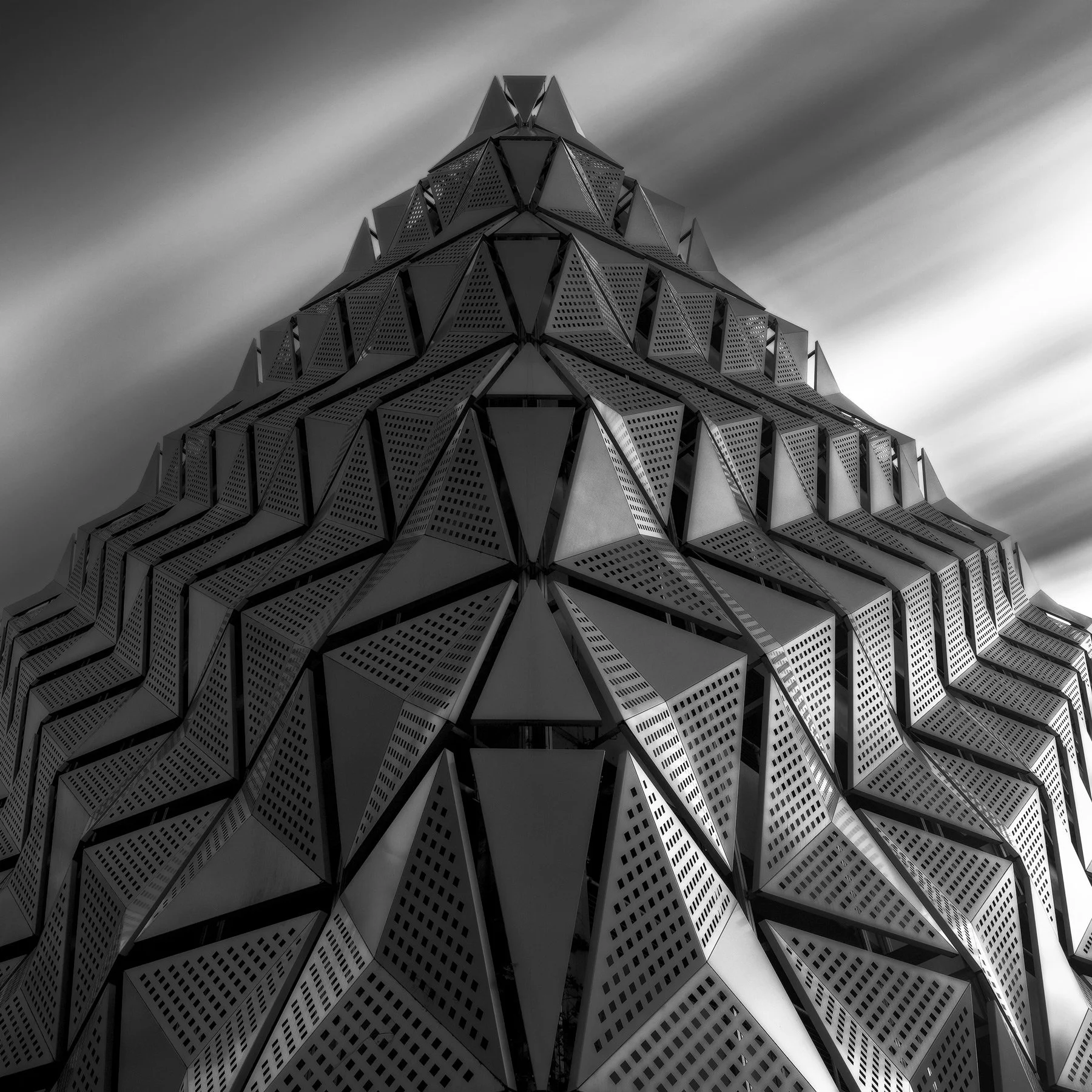 [architecture] [uk] [leeds] [blackandwhite] [square] Leeds car park facade, bold triangular perforated metal panels forming a dramatic geometric crystalline pattern. Architectural Photography by Jim Scott.