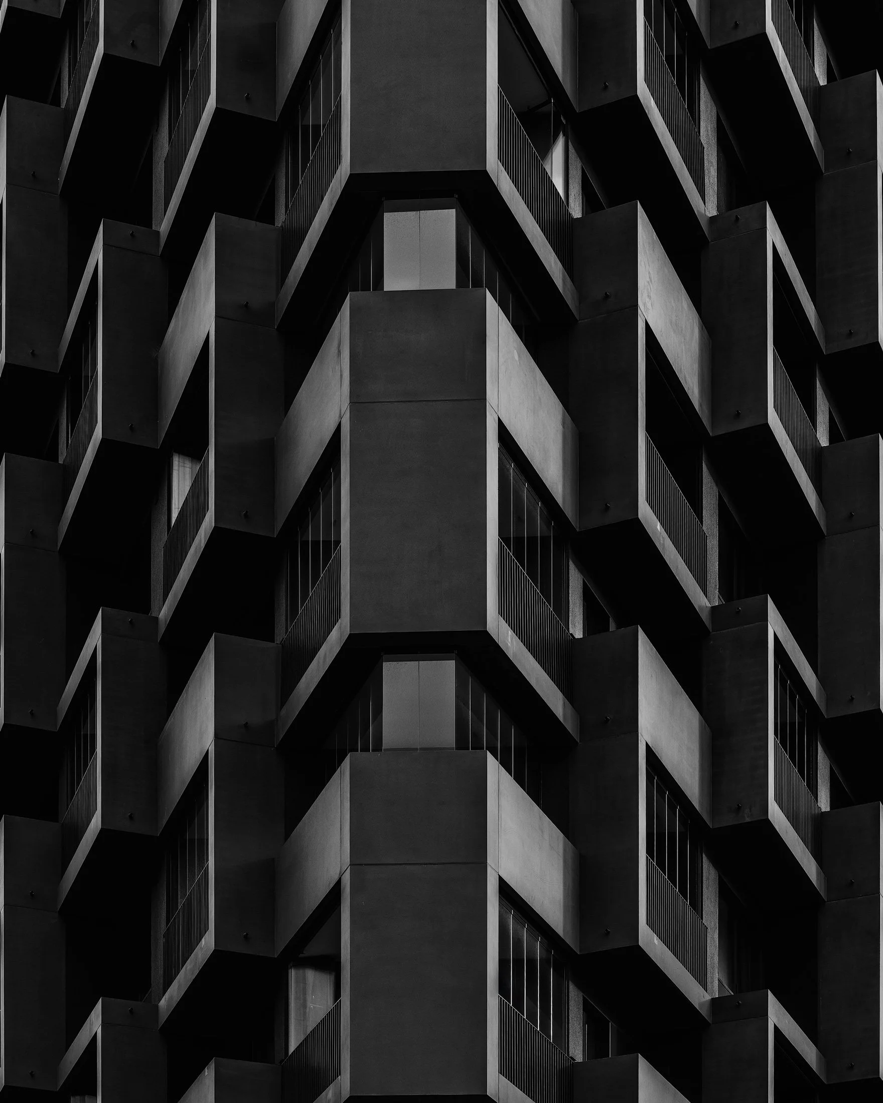 Contemporary residential architecture in HafenCity, Hamburg: A minimalist monochromatic study of a modern facade, capturing the rhythmic interplay of jutting balconies and geometric shadows. This abstract architectural photograph utilises a tight, sy