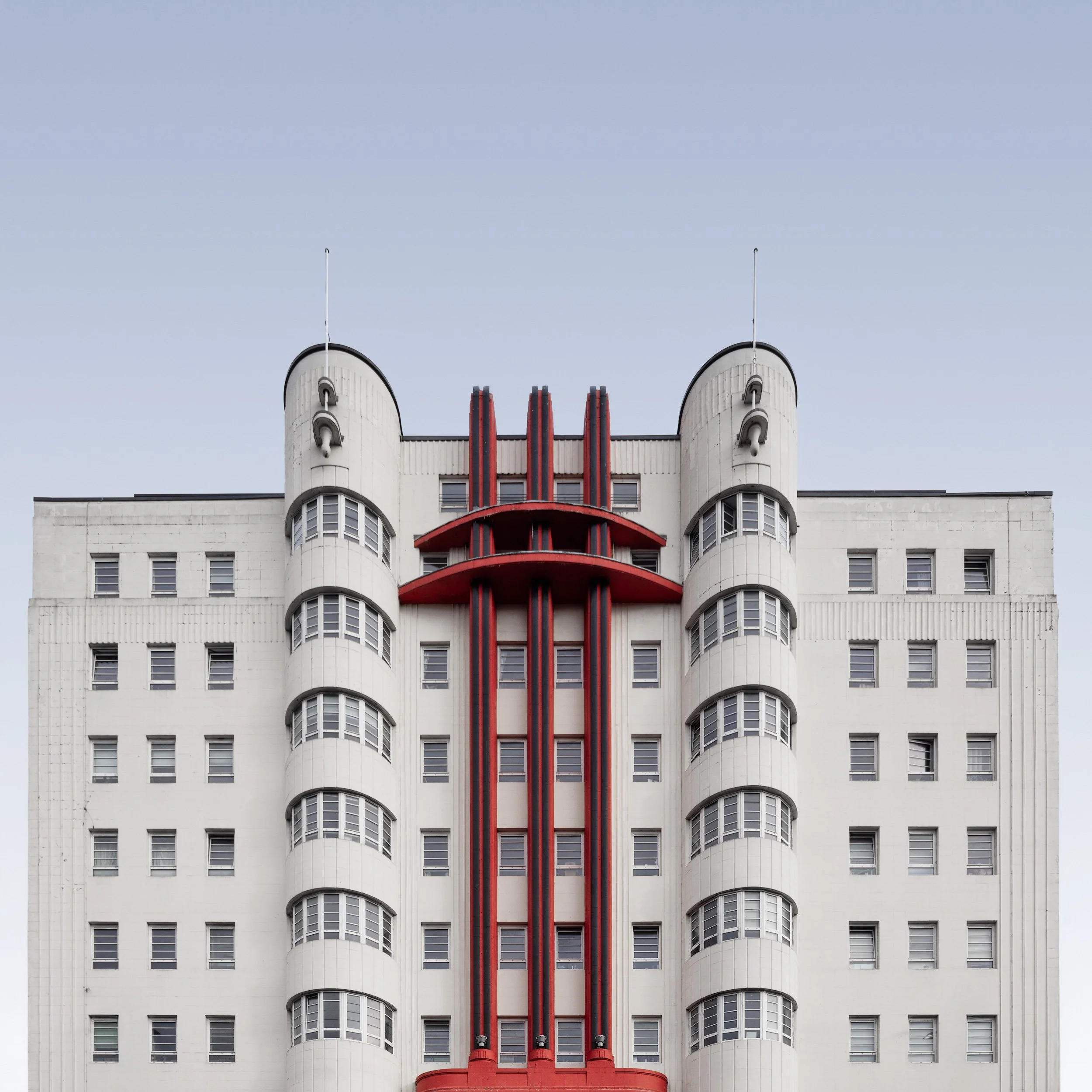 Streamline Moderne Art Deco in Glasgow, Scotland: A symmetrical architectural study of the Beresford Building, designed by William Beresford Inglis. This photograph captures the building’s iconic white facade, featuring rhythmic curved window bays an