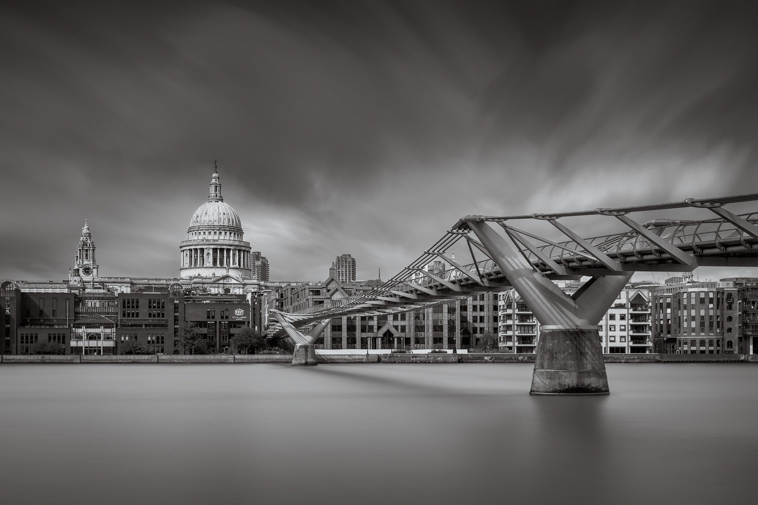 [architecture] [uk] [london] [blackandwhite] Millennium Bridge and St Paul's Cathedral London, silky River Thames long exposure, iconic cityscape black and white. Architectural Photography by Jim Scott.