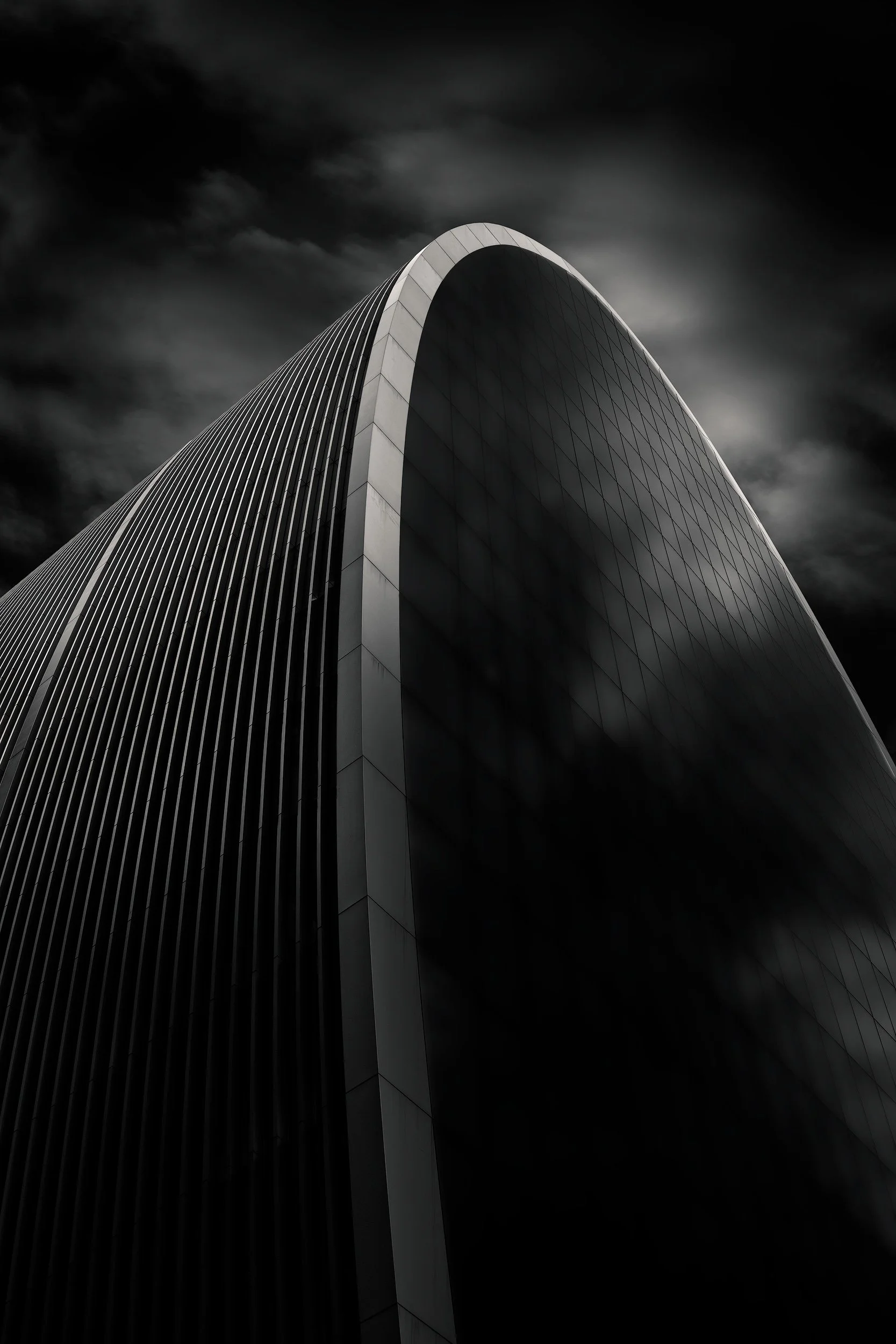 [architecture] [uk] [london] [blackandwhite] 70 St Mary Axe Can of Ham London, sweeping ribbed curved glass apex against a dark sky, low angle long exposure. Architectural Photography by Jim Scott.