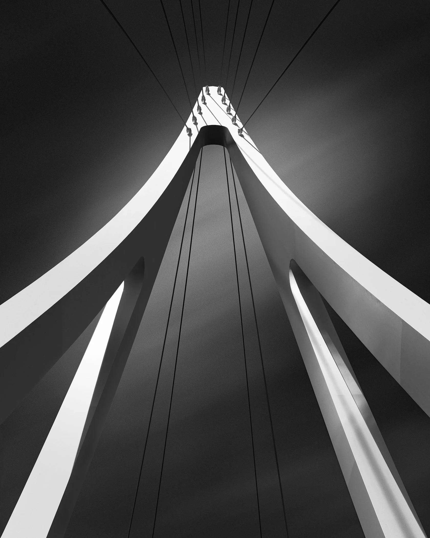 [architecture] [uk] [glasgow] [blackandwhite] Govan - Partick bridge's arched pylon and tensioned cables converge in symmetrical lines against a darkened sky. Architectural Photography by Jim Scott