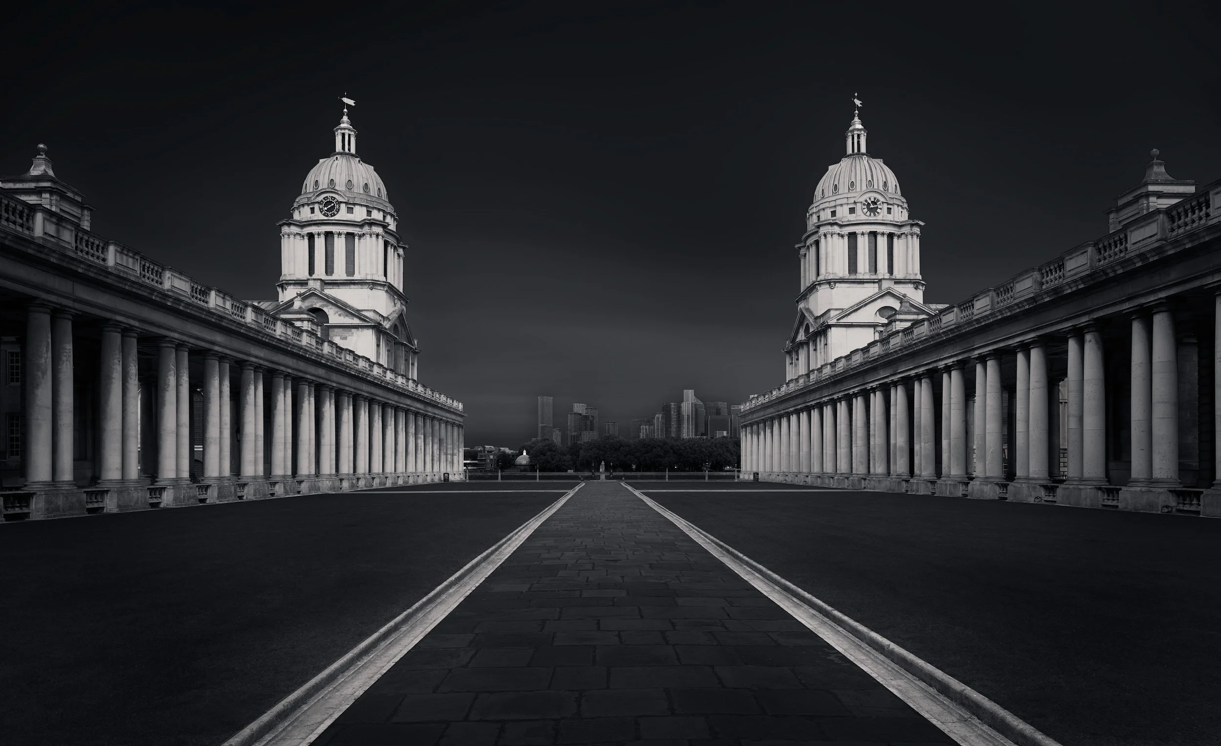 Eighteenth-century Baroque architecture in Greenwich, London: A dramatic study of the Old Royal Naval College, designed by Sir Christopher Wren. This architectural photograph captures the symmetrical twin domes of the King William and Queen Mary Cour