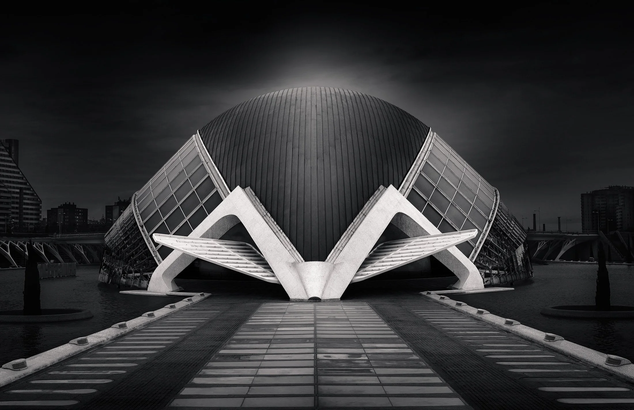 Neo-futurist architecture at the City of Arts and Sciences, Valencia: A monumental monochromatic study of L'Hemisfèric, designed by Santiago Calatrava. This symmetrical architectural photograph captures the building’s iconic "eye" structure, featurin