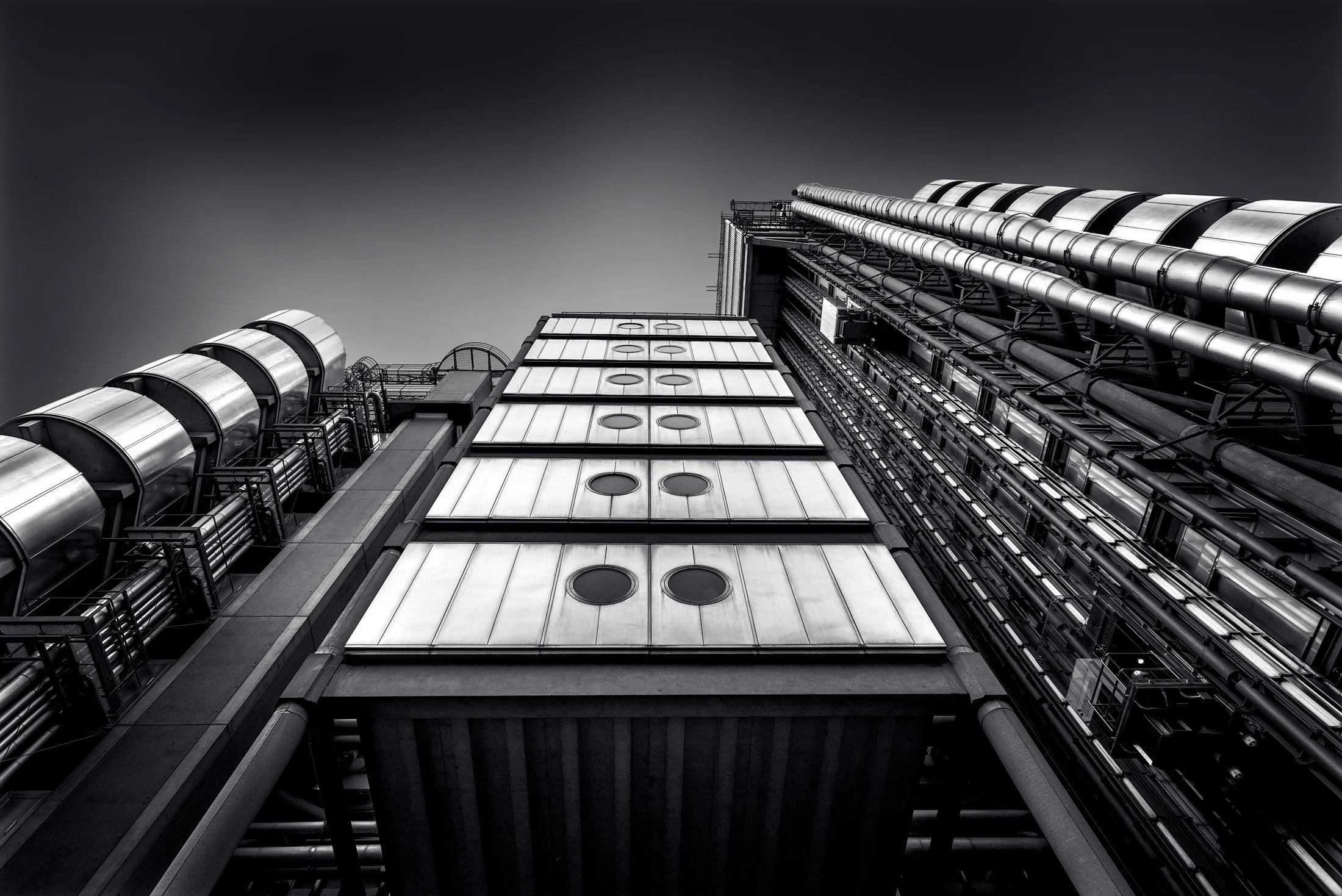 [architecture] [uk] [london] [blackandwhite] Lloyd's of London Richard Rogers high-tech exterior, looking up exposed steel ducts and service towers, bold black and white. Architectural Photography by Jim Scott.