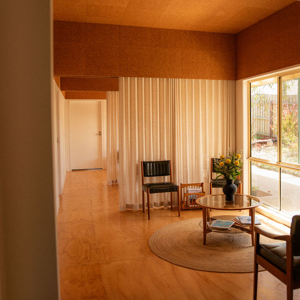 Warm and welcoming waiting room design for a medical clinic in Warrnambool. Commercial interior design by Lane Architects featuring cork ceilings and timber flooring to create a calming environment.