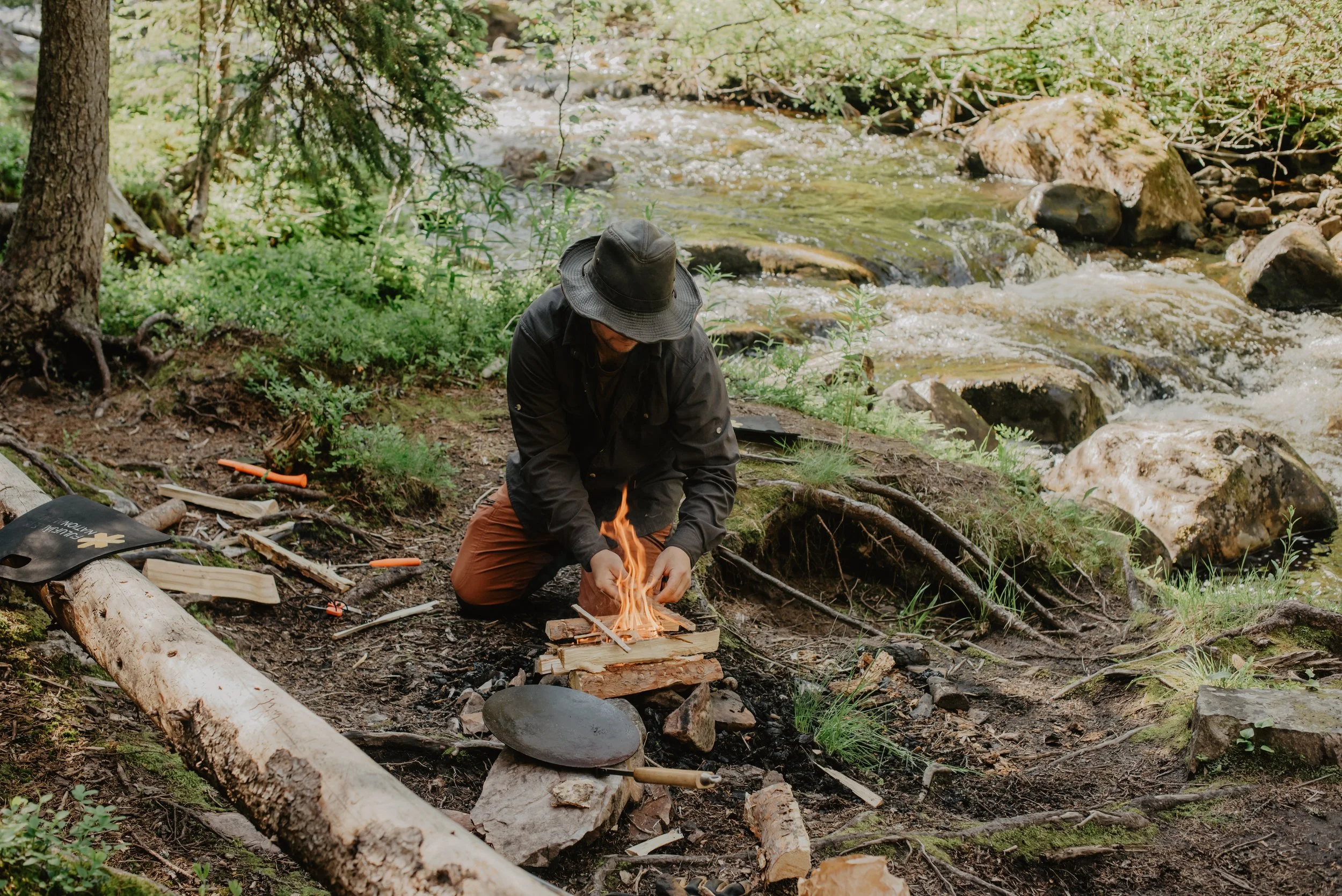 Guid makes a fire to cook lunch for guests at brudslöjan waterfall