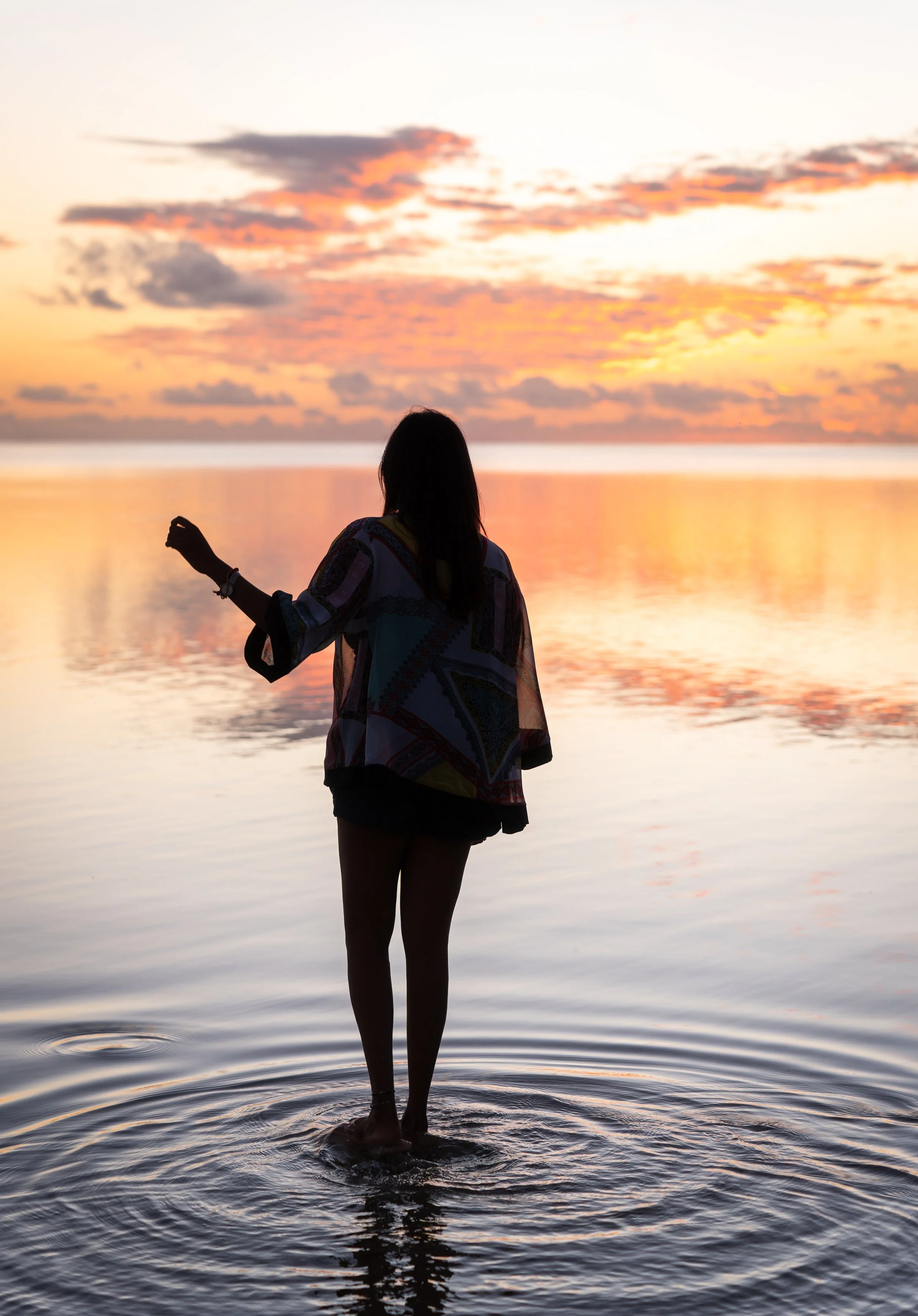 Woman admiring sunset at Le Morne in Mauritius during photoshoot at the beach.
