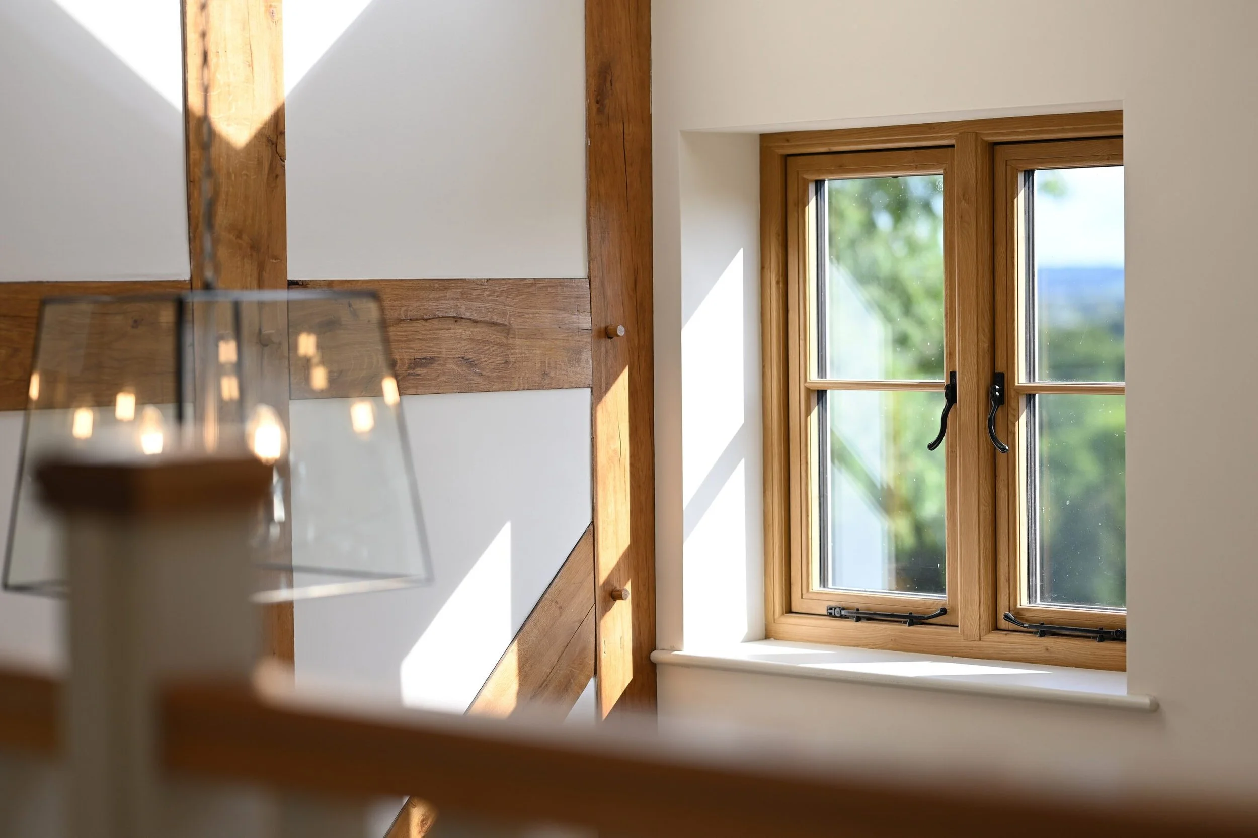 Wood effect UPVC window taken inside traditional kitchen with teardrop handles in black