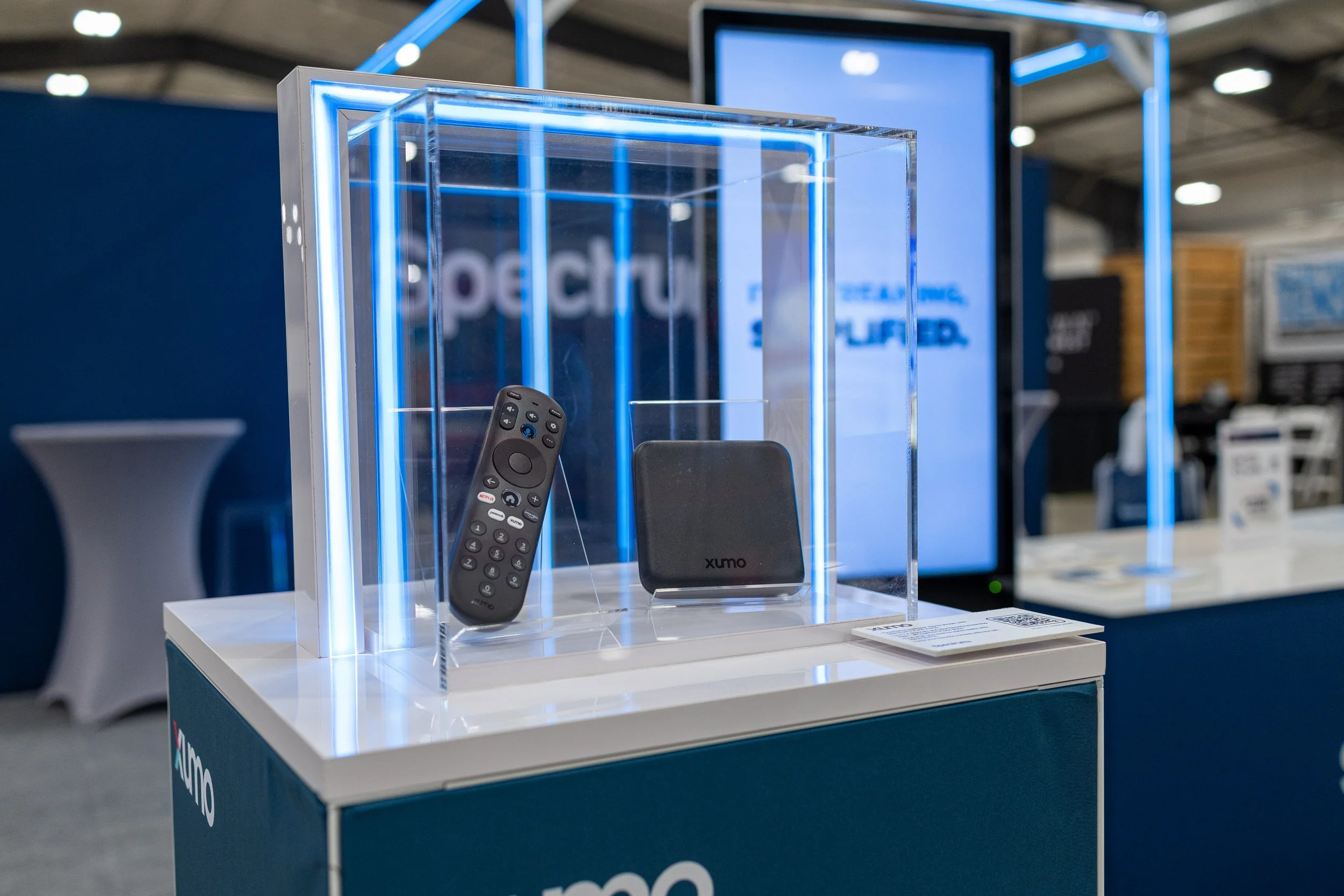 Xumo streaming device and remote displayed in an illuminated glass case at a technology expo