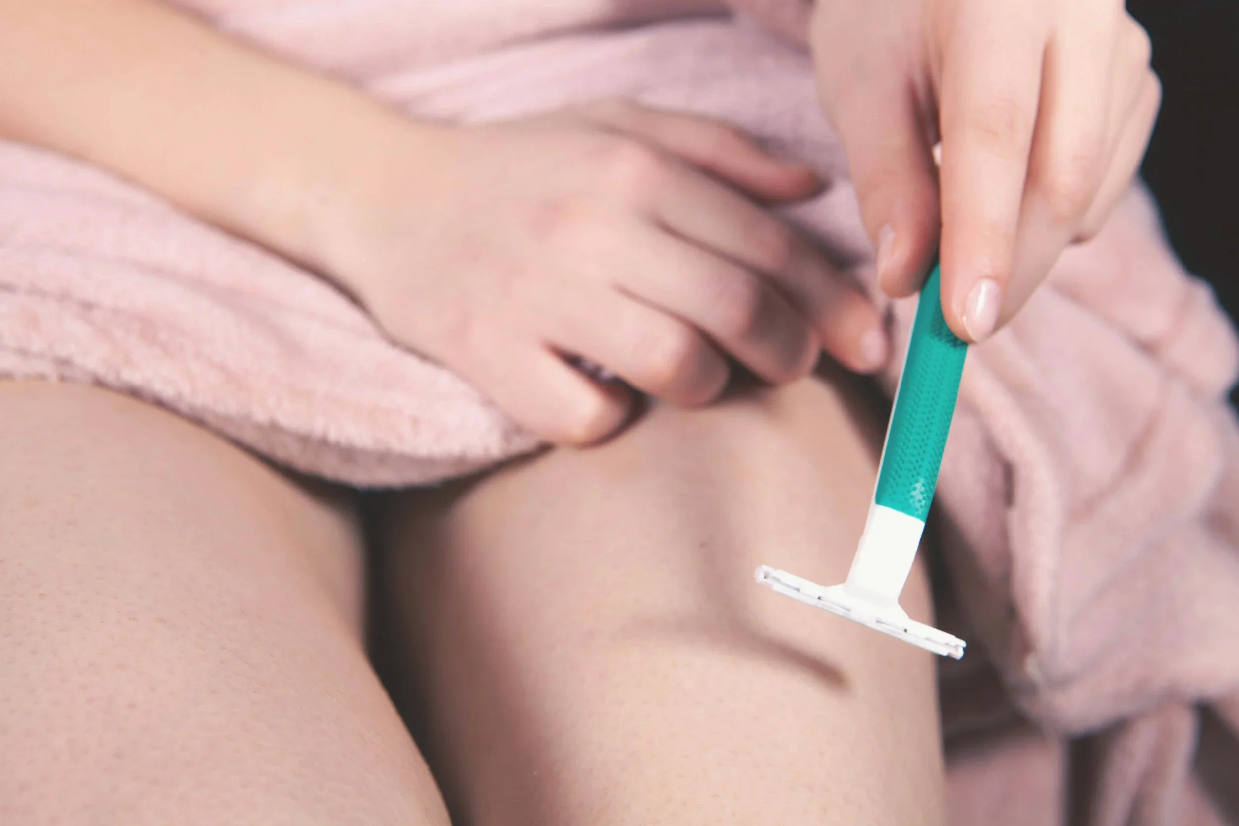 Closeup of a woman shaving her leg