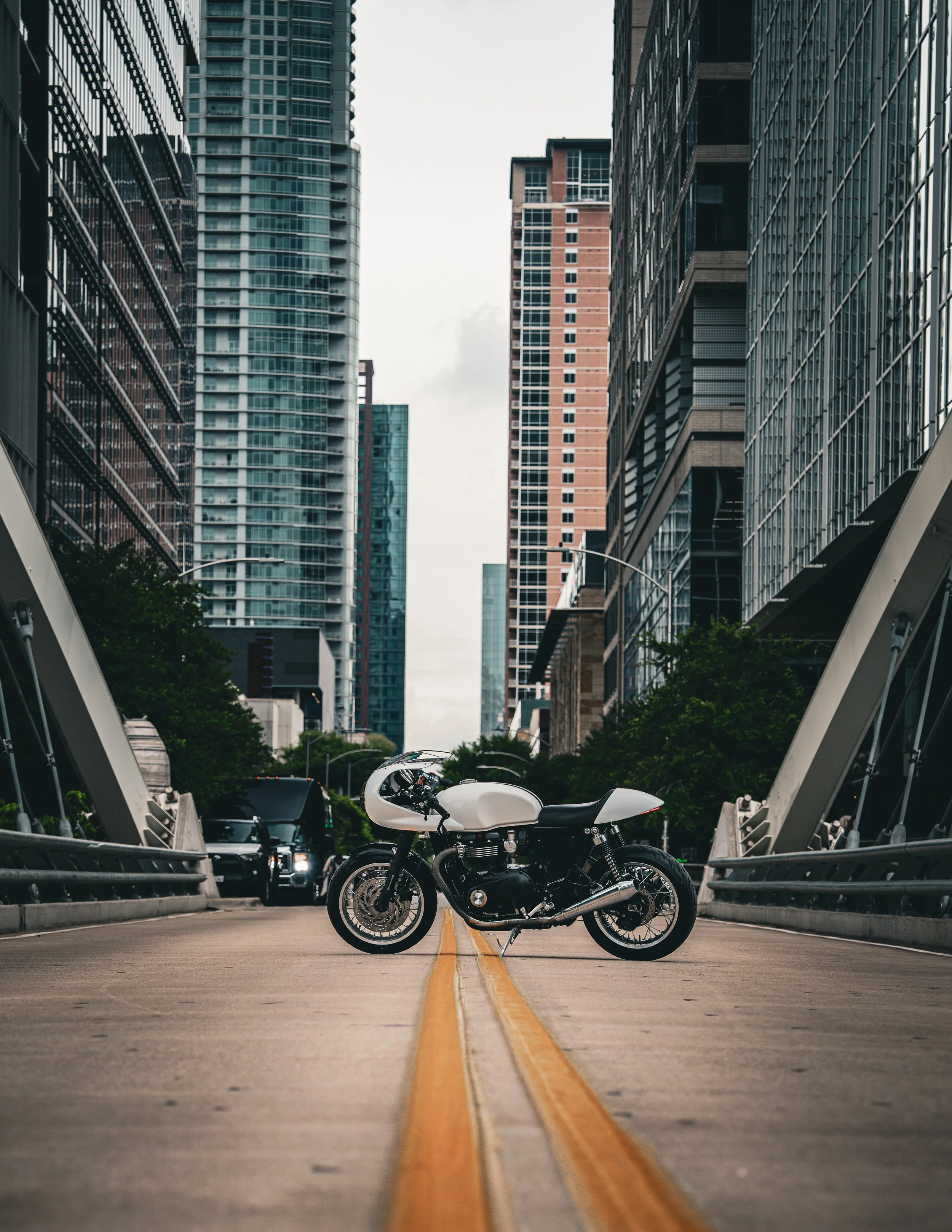 White cafe racer motorcycle photographed in an urban setting by creATX Media, an Austin/Round Rock/Cedar Park commercial photography and video agency.