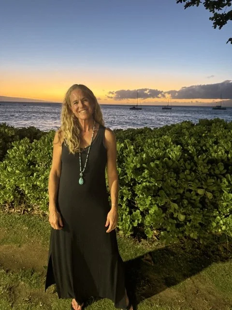 Paige Smith portrait in front of the ocean and red sky sunset