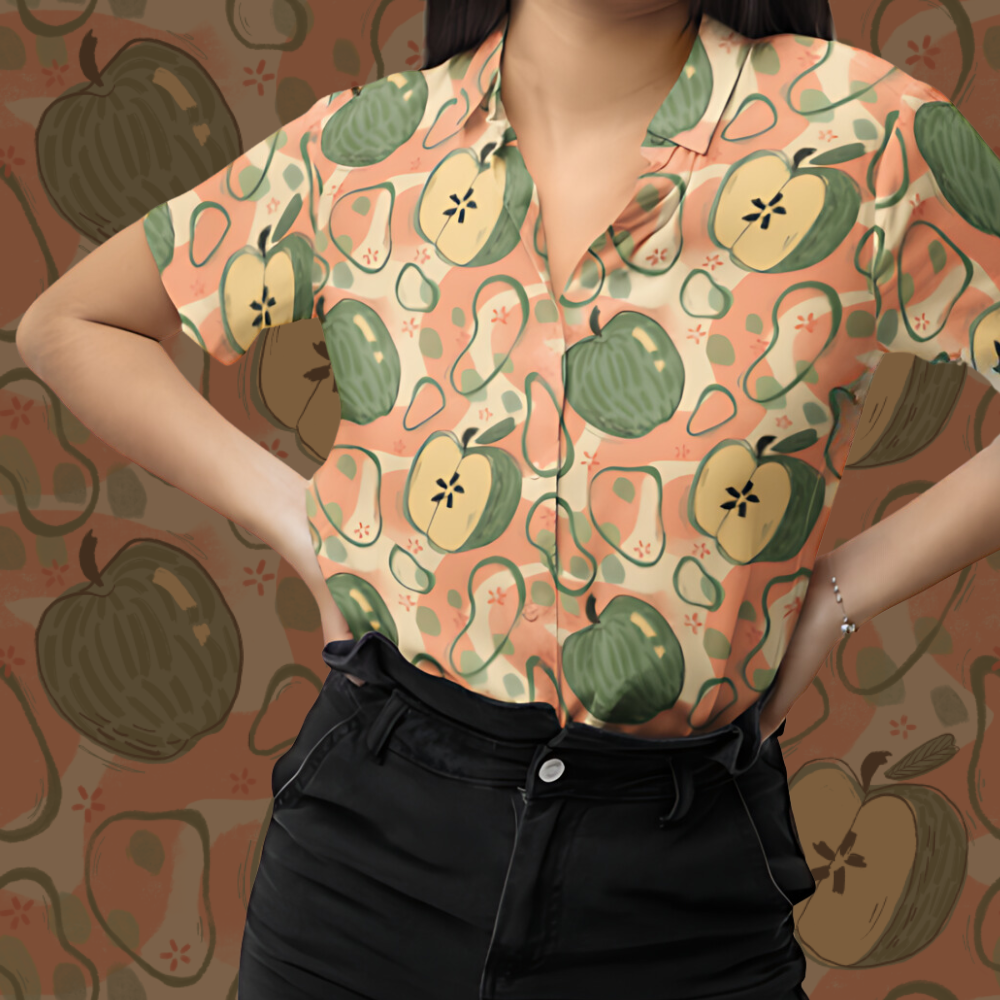 An image of someone modeling the appalooza shirt, which is green apples with pink background patterns